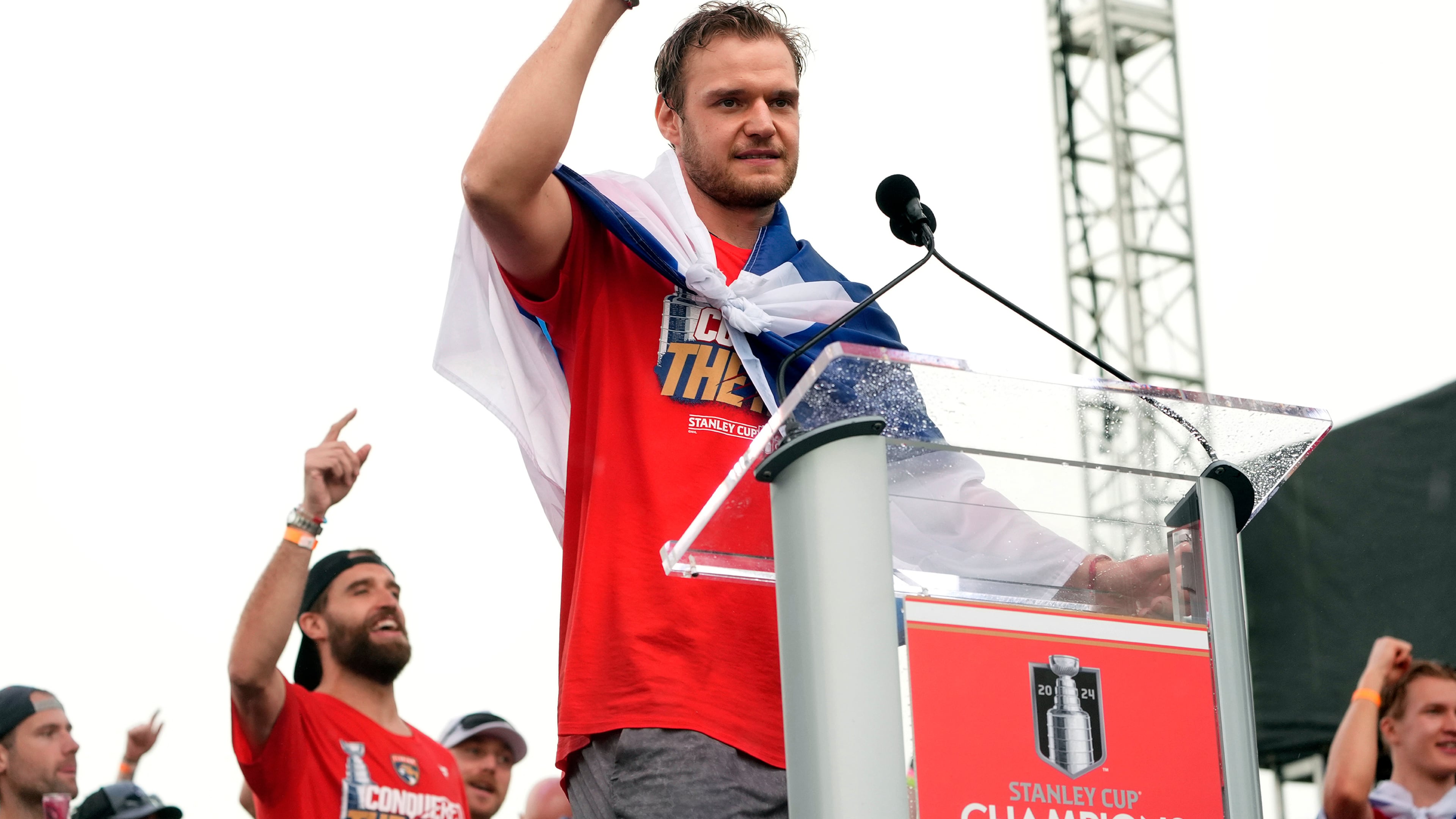 FILE - Florida Panthers' Aleksander Barkov, front, gestures while speaking during an NHL hockey rally and parade to celebrate the NHL hockey team winning the Stanley Cup, Sunday, June 30, 2024, in Fort Lauderdale, Fla.. (AP Photo/Marta Lavandier, File)