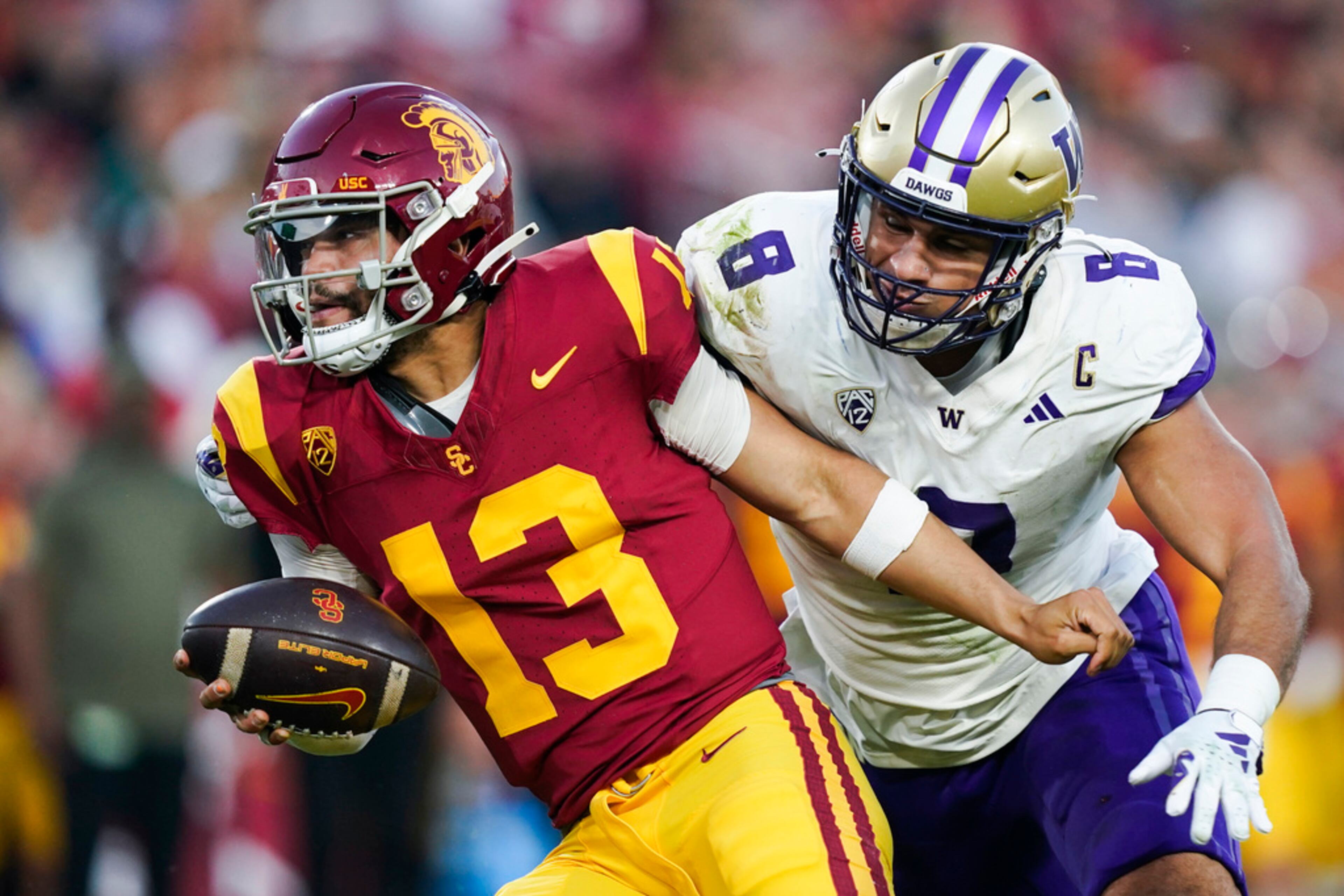 Southern California quarterback Caleb Williams, left, gets away from Washington defensive end Bralen Trice during the first half of an NCAA college football game Saturday, Nov. 4, 2023, in Los Angeles. (AP Photo/Ryan Sun)