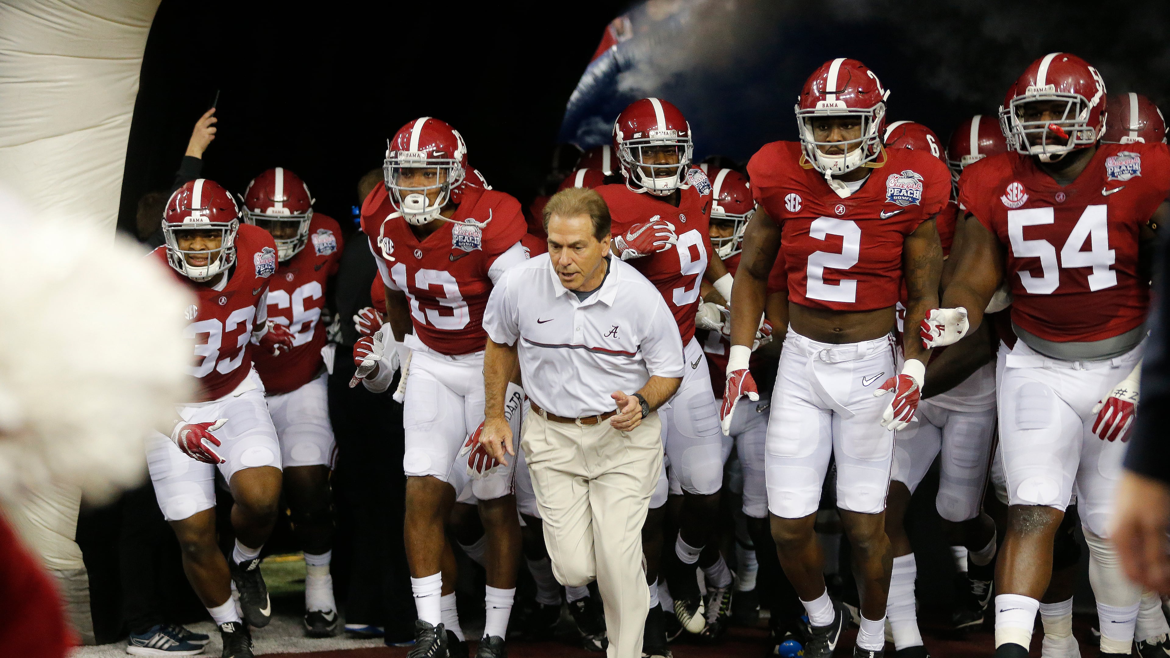 In this Saturday, Dec. 31, 2016, photo, Alabama head coach Nick Saban and players enter the field for the first half of the Peach Bowl NCAA college football playoff game against Washington in Atlanta. The system of core beliefs, this daily guidebook for going about your business, has carried Saban and Alabama to the brink of yet another national championship. Call it The Process. Call it the Saban Way. It's hard to call it anything but successful. (AP Photo/John Bazemore)