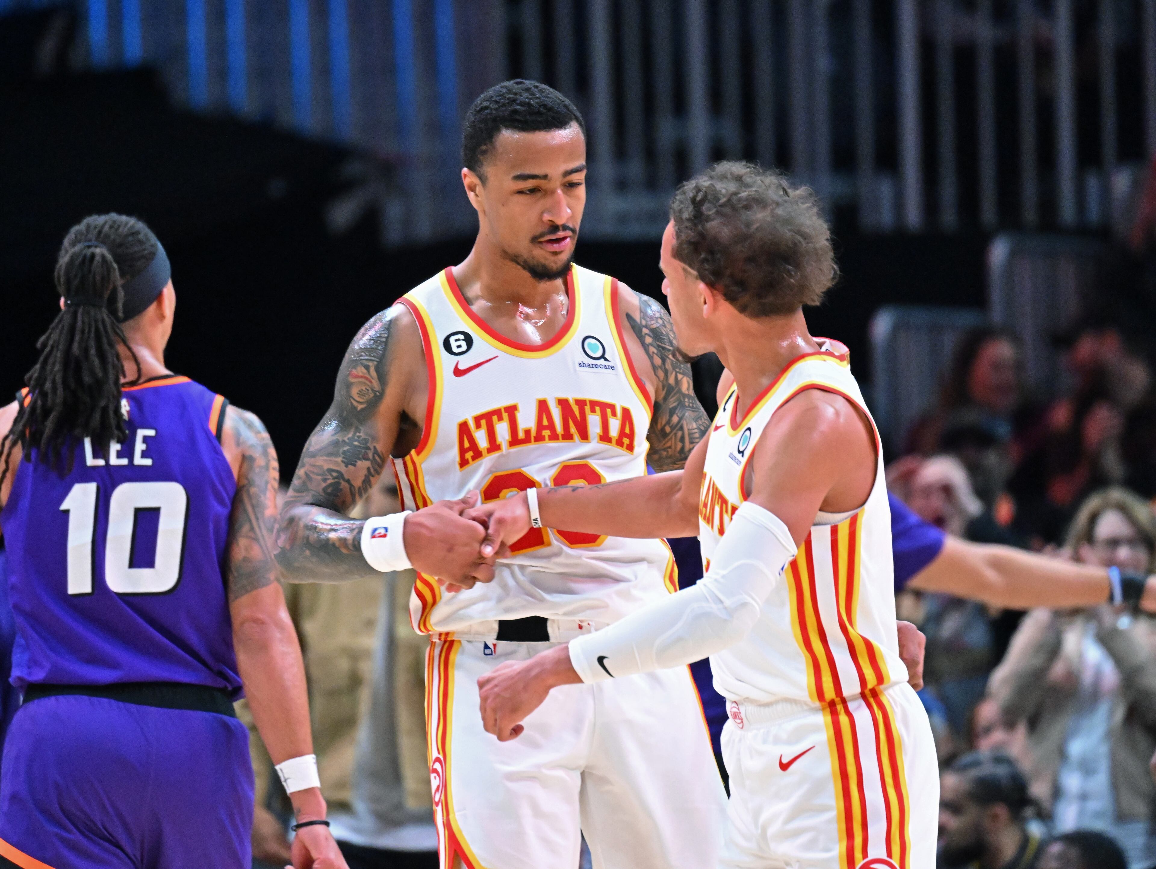 Atlanta Hawks forward John Collins (left) and guard Trae Young celebrate during the second half in an NBA basketball game at State Farm Arena, Thursday, Feb. 9, 2023, in Atlanta. The Hawks won 116-107. (Hyosub Shin / Hyosub.Shin@ajc.com)