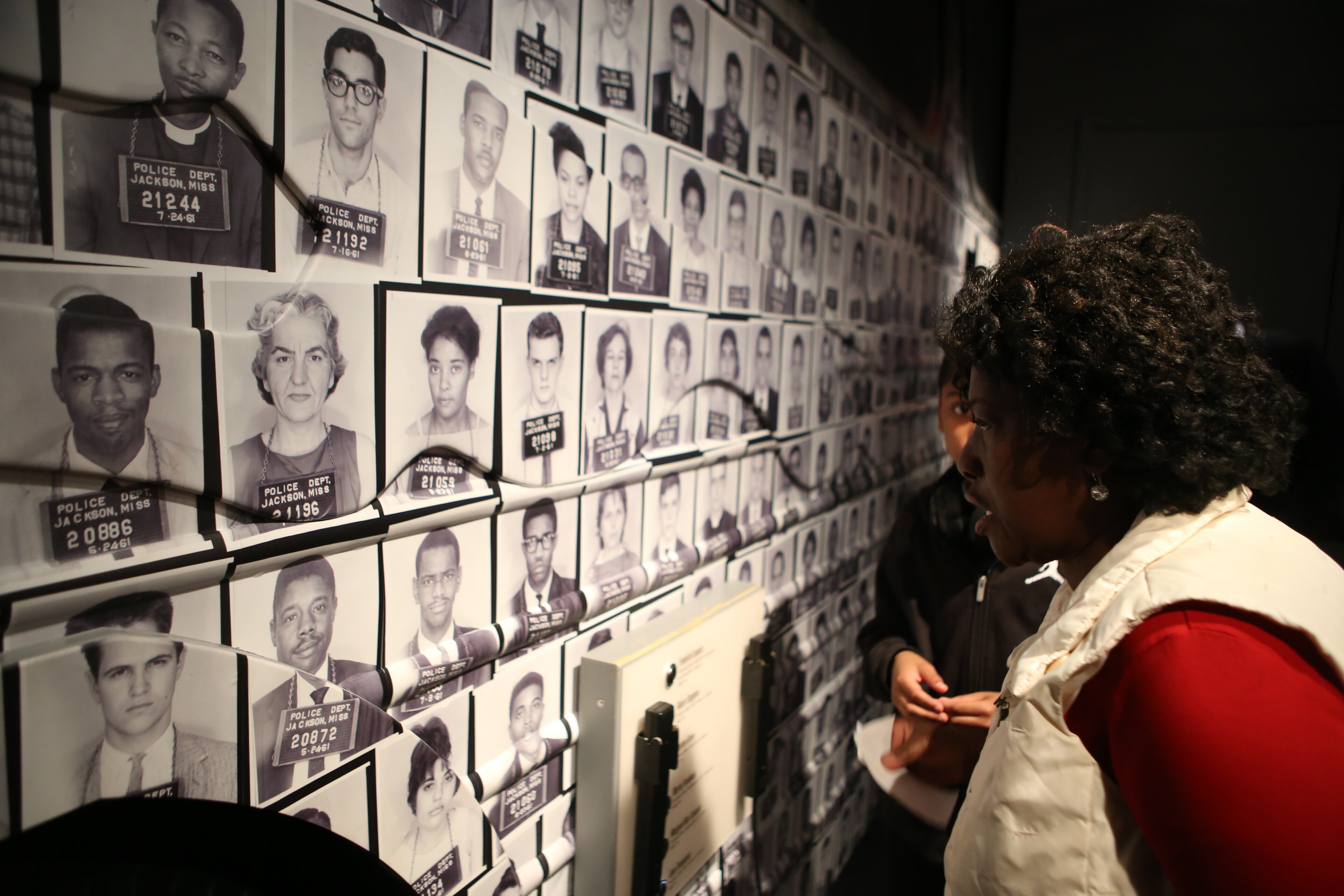 February 14, 2017, Atlanta, Georgia - Cassandra Harris and Ahmir Brown look through the names and faces of the many protestors arrested and had mug shots taken of, including Representative John Lewis (far left, center image - #20886) at the National Center for Civil and Human Rights in Atlanta, Georgia, on Tuesday, February 14, 2017. (HENRY TAYLOR / HENRY.TAYLOR@AJC.COM)