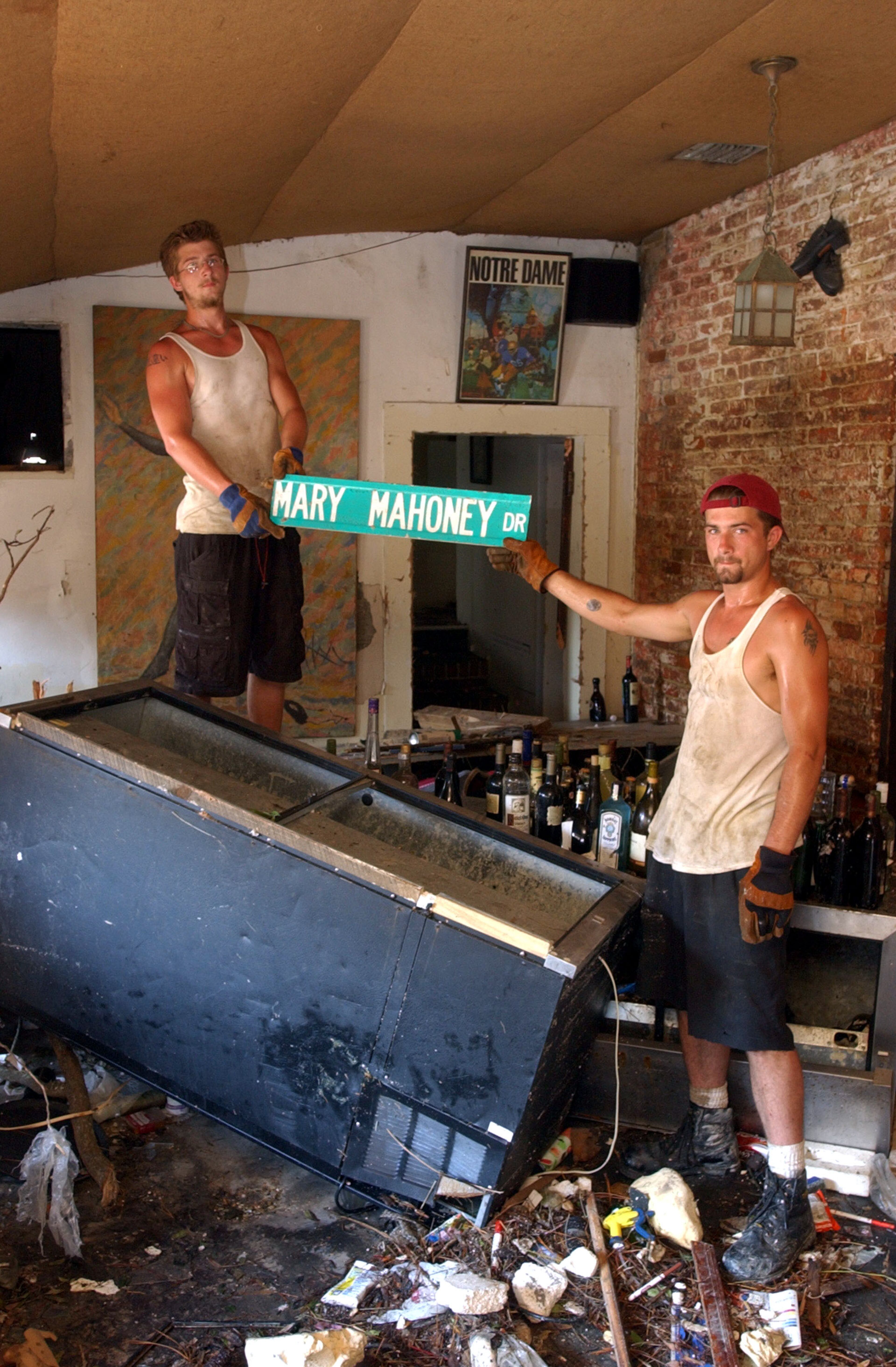 Mary Mahoney's Restaurant employees Thomas Vincent (L) and Chris Vincen hold up a street sign that was blown off its pole by Hurricane Katrina from the street outside which they found in the restaurant's bar September 2, 2005 in Biloxi, Mississippi. The historic restaurant hopes to reopen in six weeks. (Photo by Barry Williams/Getty Images)