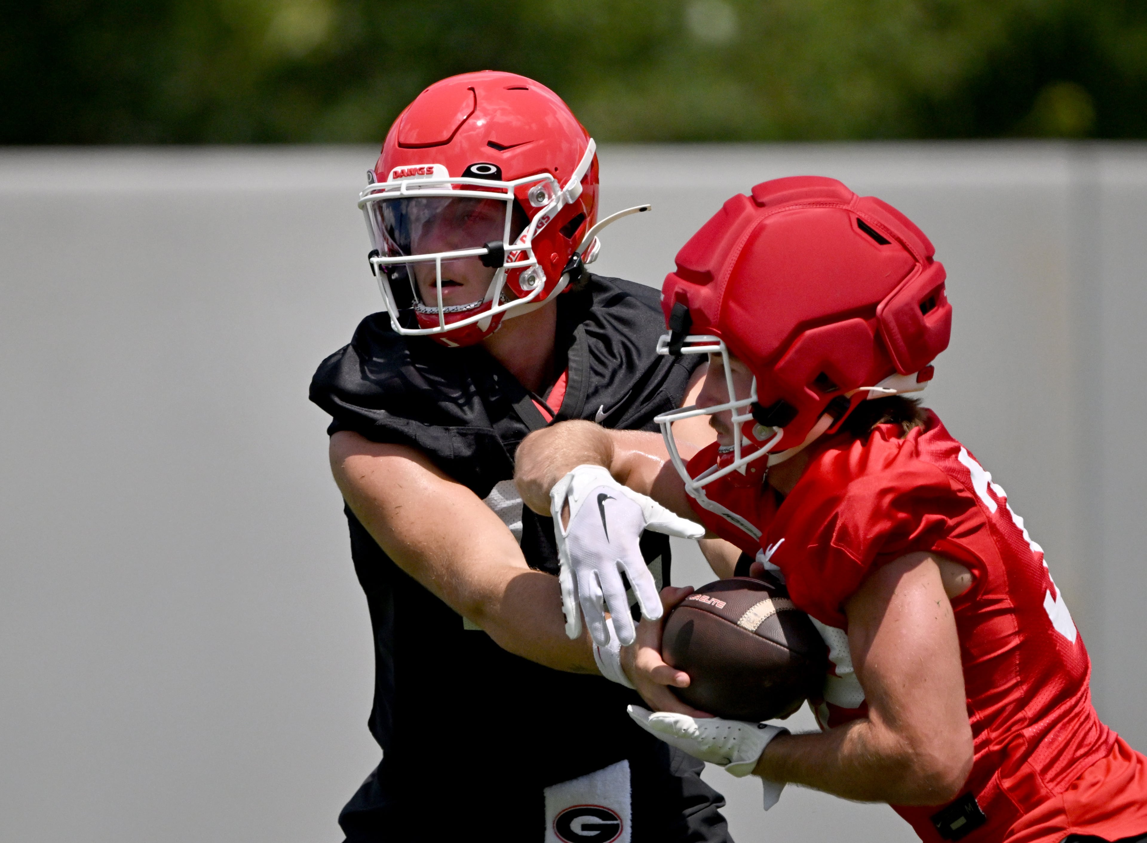 Georgia quarterback Ryan Puglisi (12) makes a handoff to Georgia running back Cash Jones (32) during football practice at the University of Georgia practice facility, Thursday, July 31, 2025, in Athens. (Hyosub Shin / AJC)