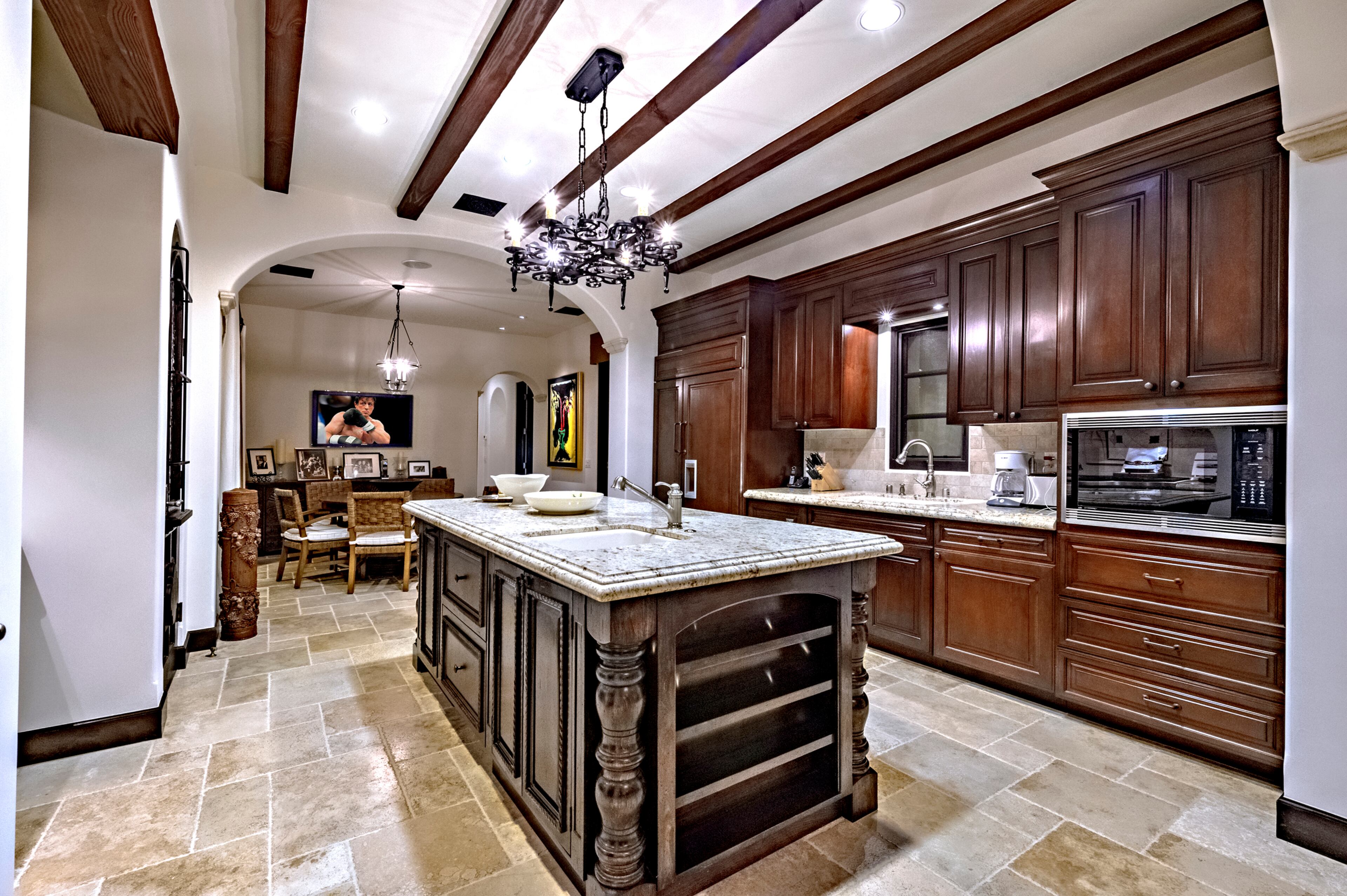 The spacious kitchen features a large wood-and-stone island. Rocky star and all-around action movie legend Sylvester Stallone has put his desert home in a gated La Quinta, Calif., community up for sale at $4.2 million. The 5,173-square-foot, four-bedroom, 4.5-bathroom home features details such as arched doorways, exposed beams, and plenty of space to hang his paintings, since he’s not just an actor—he’s an artist, too. Listing courtesy of Josh Reef, Hurwitz James Company