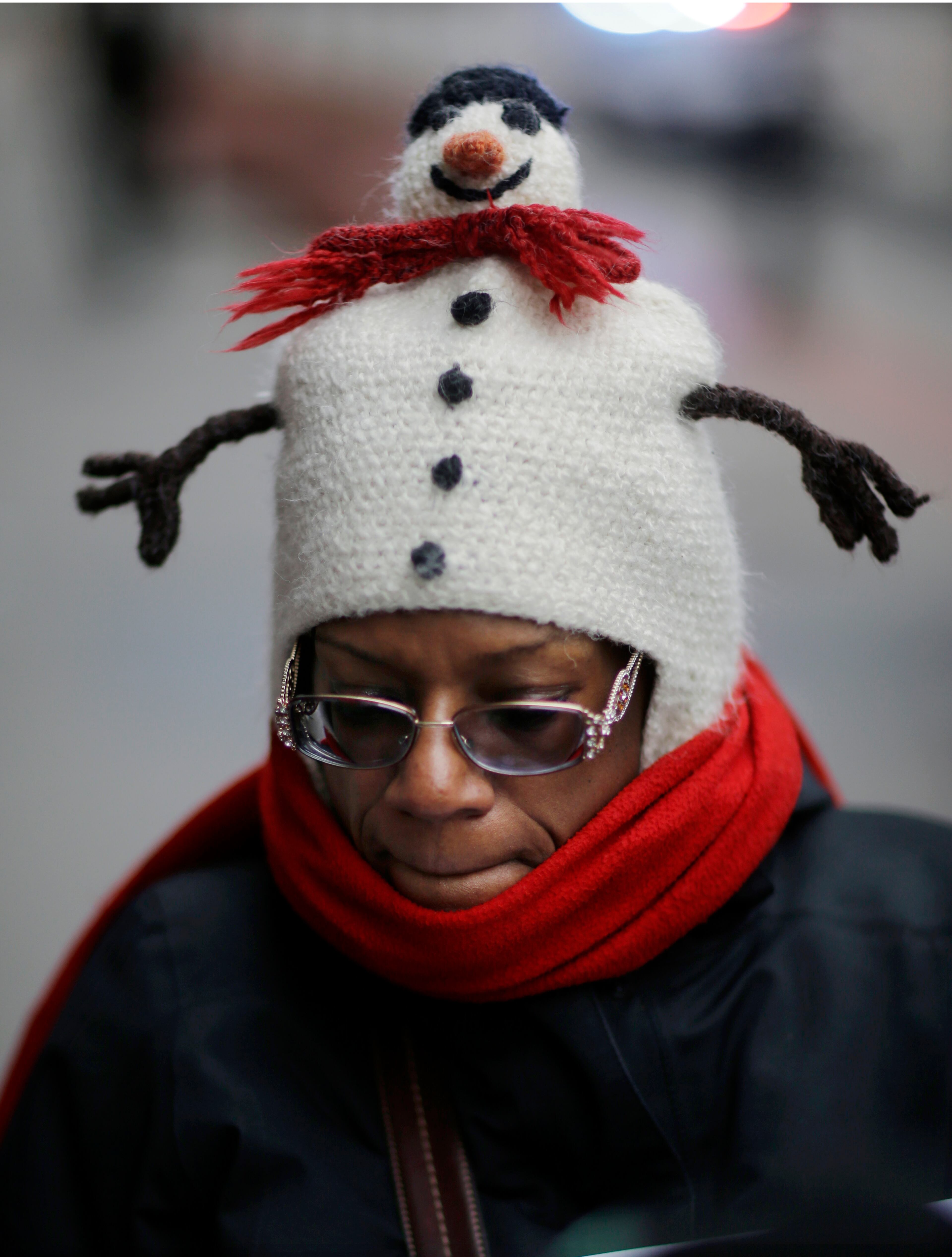 Rochelle Drummer wears a decorative hat as she bundles against the cold in Newark , N.J., Sunday, Dec. 8, 2013, as a winter storm moved into the region. Parts of Pennsylvania and southern New Jersey saw more than 3 inches (7.5 centimeters) of accumulation, making driving dangerous for millions of residents nationwide.
