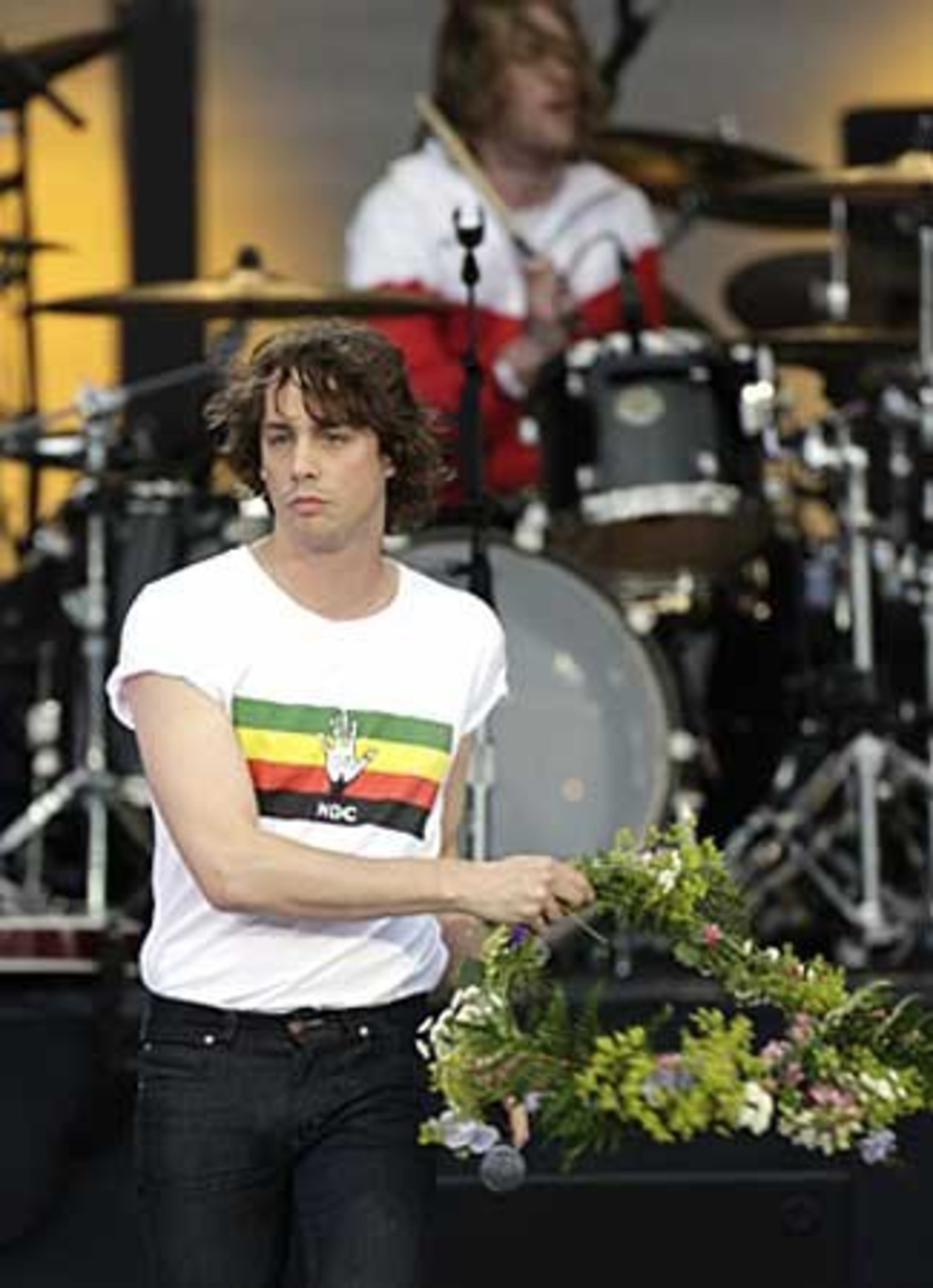 British singer Johnny Borrell of Razorlight throws a wreath prior to performing at the 46664 charity concert.