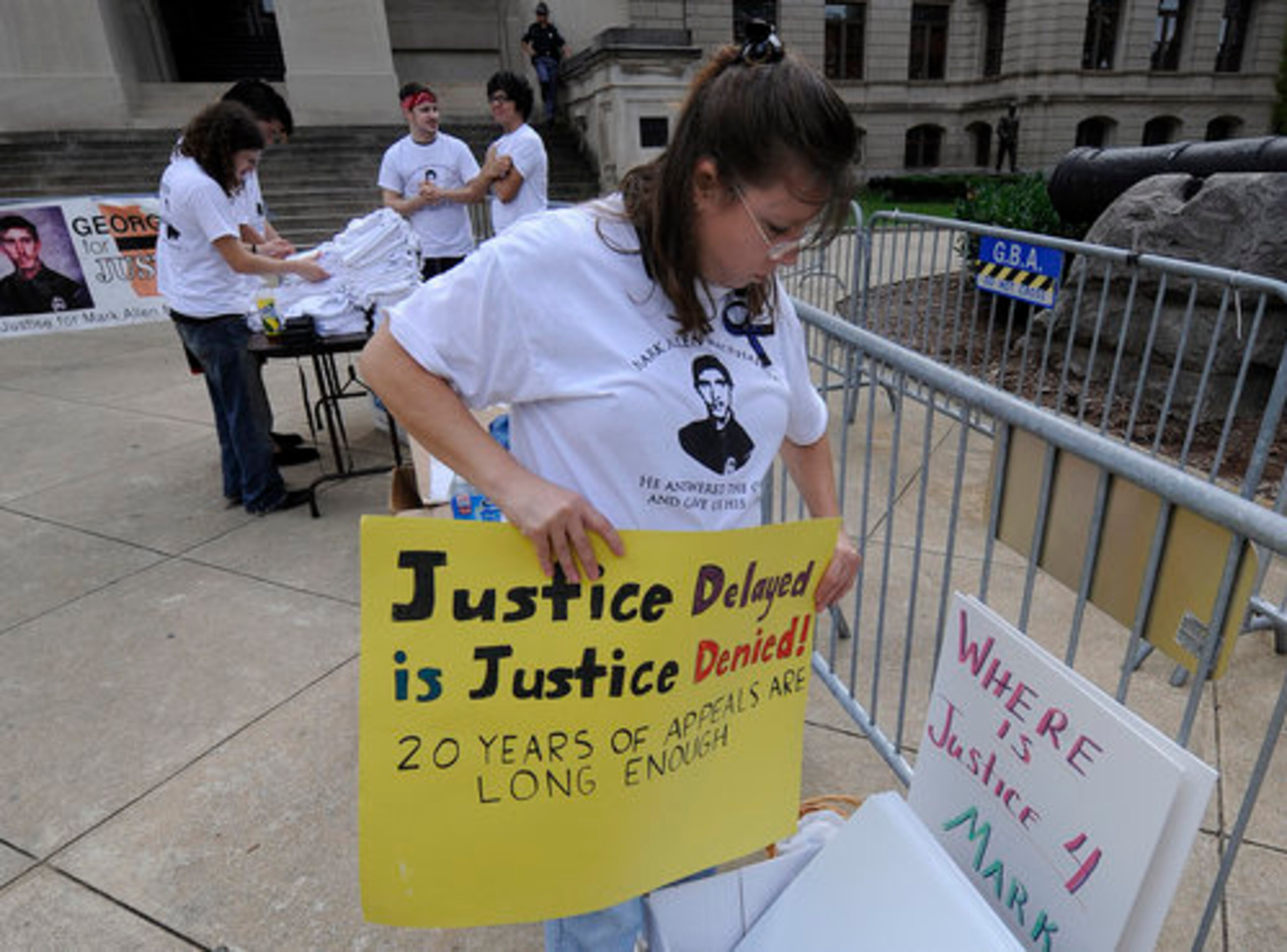 Kathy MacPhail McQuary, of Columbus, organizes signs during a rally at the state capitol Thursday. Family and friends of Mark Allen MacPhail Sr., police officer allegedly killed by Troy Davis, attended the rally to draw attention to the slain officer. She was his sister. The group held signs and wore t-shirts with a picture of MacPhail.
