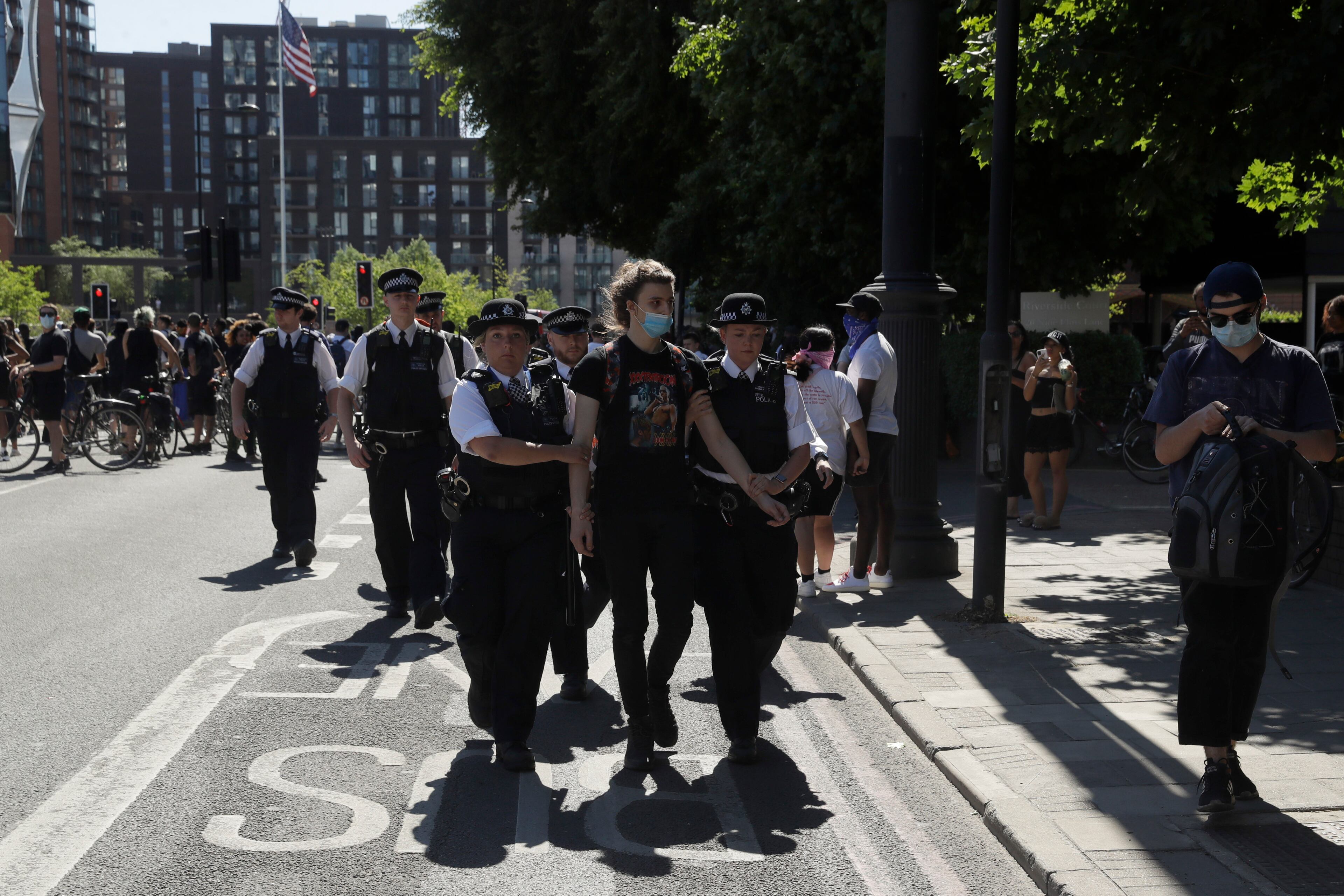 A demonstrator is removed by police officers from outside the U.S. embassy after people marched there from Trafalgar Square in central London on Sunday, May 31, 2020, to protest against the recent killing of George Floyd in Minneapolis, USA. US Police officers have been detained in connection with the death of George Floyd that has led to protests in many countries and across the U.S.(AP Photo/Matt Dunham)