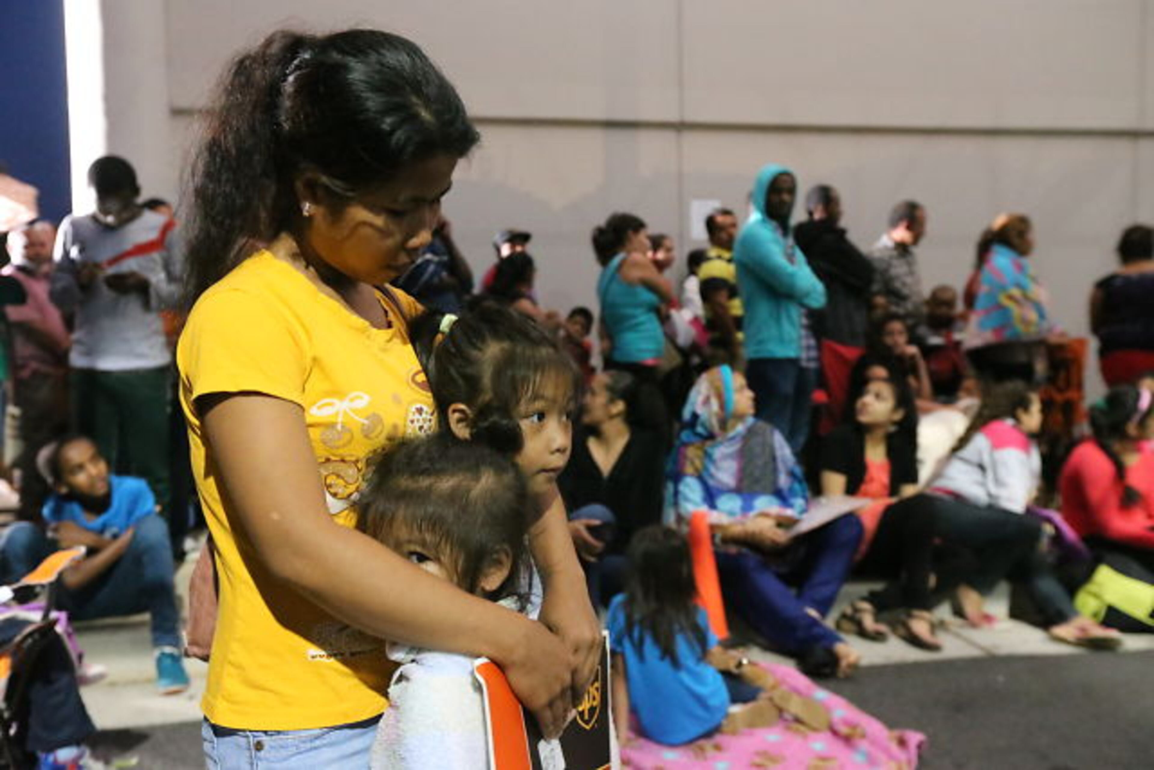 Hoping to get their children enrolled in DeKalb County Schools, immigrant families spent Thursday night and early Friday lined up with their children outside district headquarters.