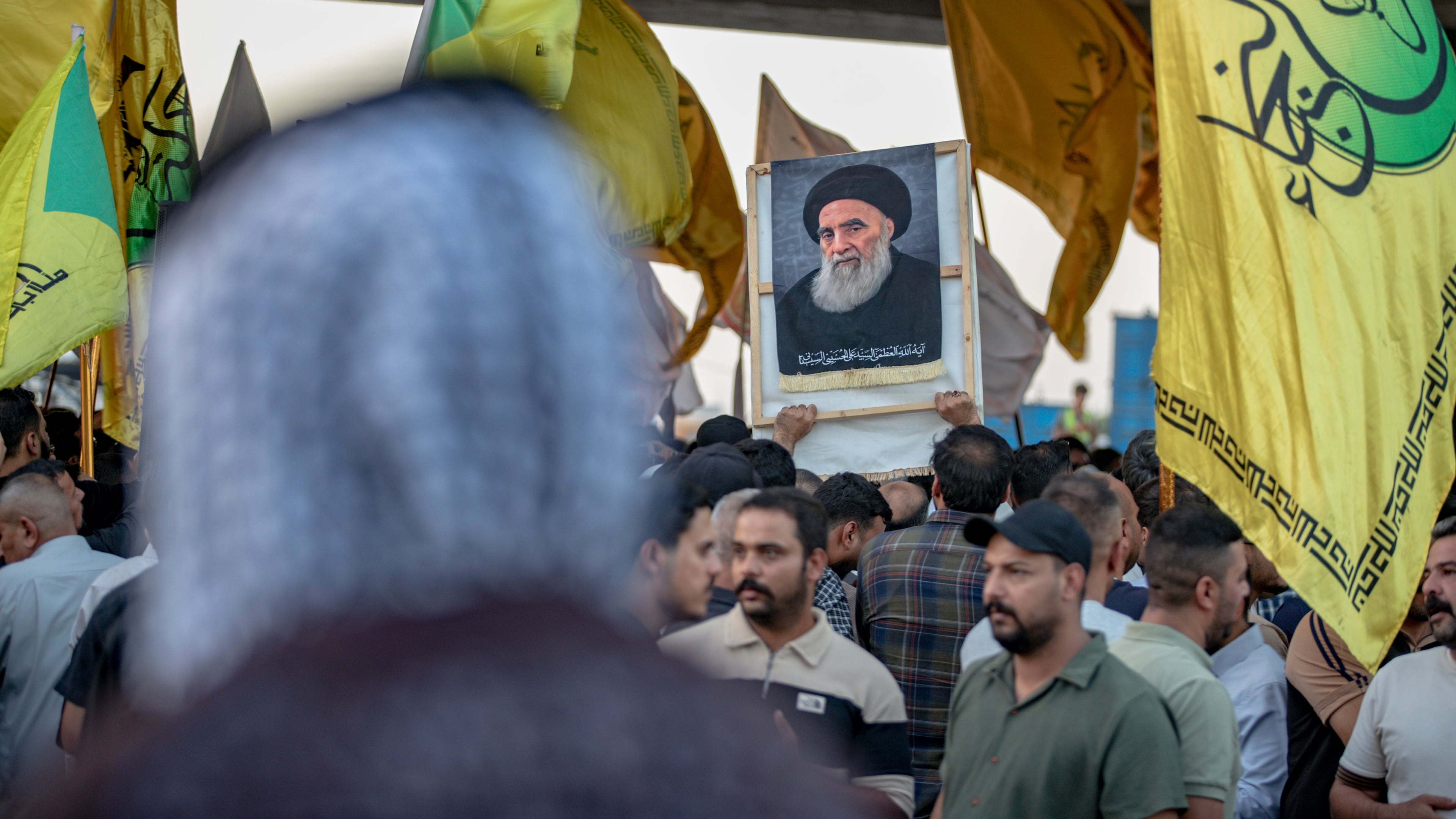A demonstrator holds a portrait of Iraq's top Shiite cleric, Grand Ayatollah Ali al-Sistani, during a protest against the suspension of flights between Iraq and Iran outside Najaf International Airport in Najaf, Iraq, Monday, Sept. 28, 2026. (AP Photo/Anmar Khalil)