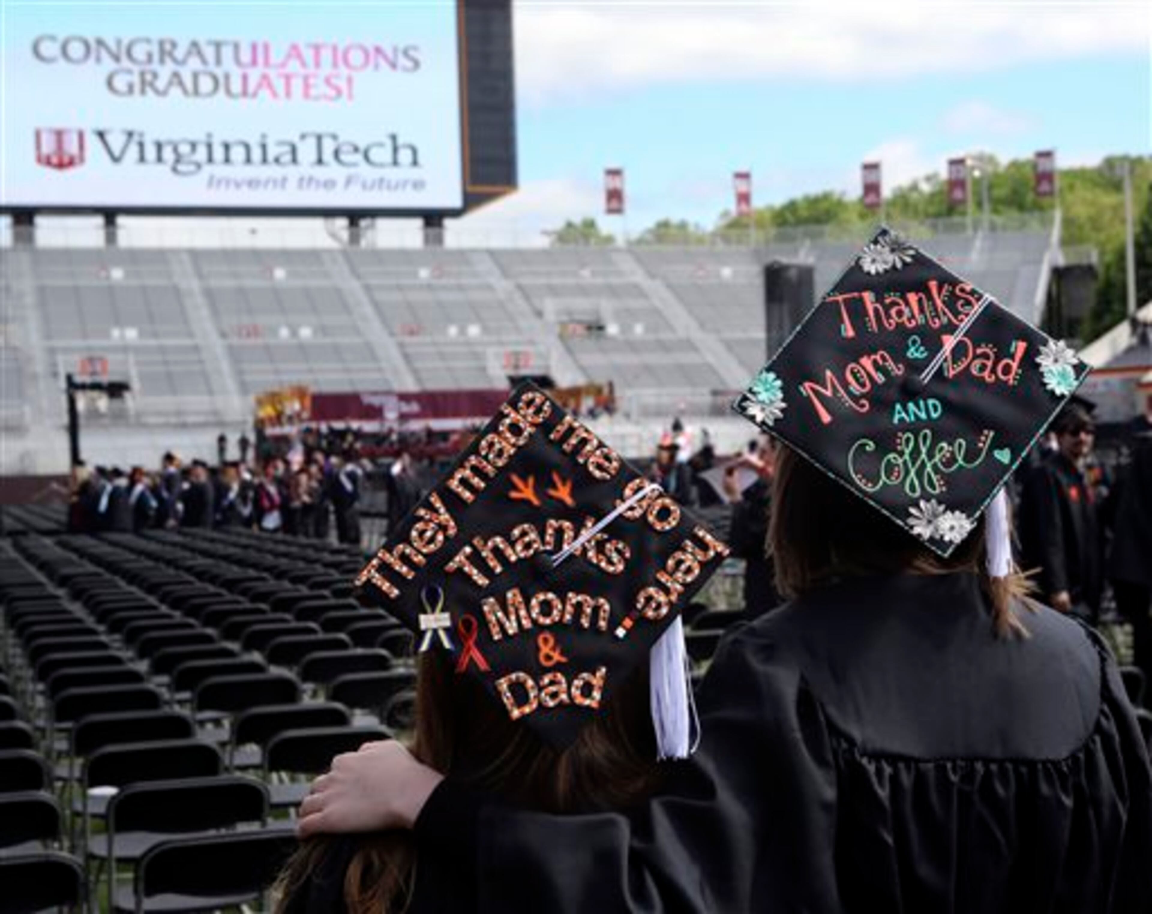 Graduates Megan Downing left, and Carlen Rowan right, take in the scene of their Virginia Tech Class of 2014 graduation ceremony held in Lane Stadium on the Virginia Tech campus in Blacksburg Friday May 16 2014. (AP Photo/The Roanoke Times, Matt Gentry)