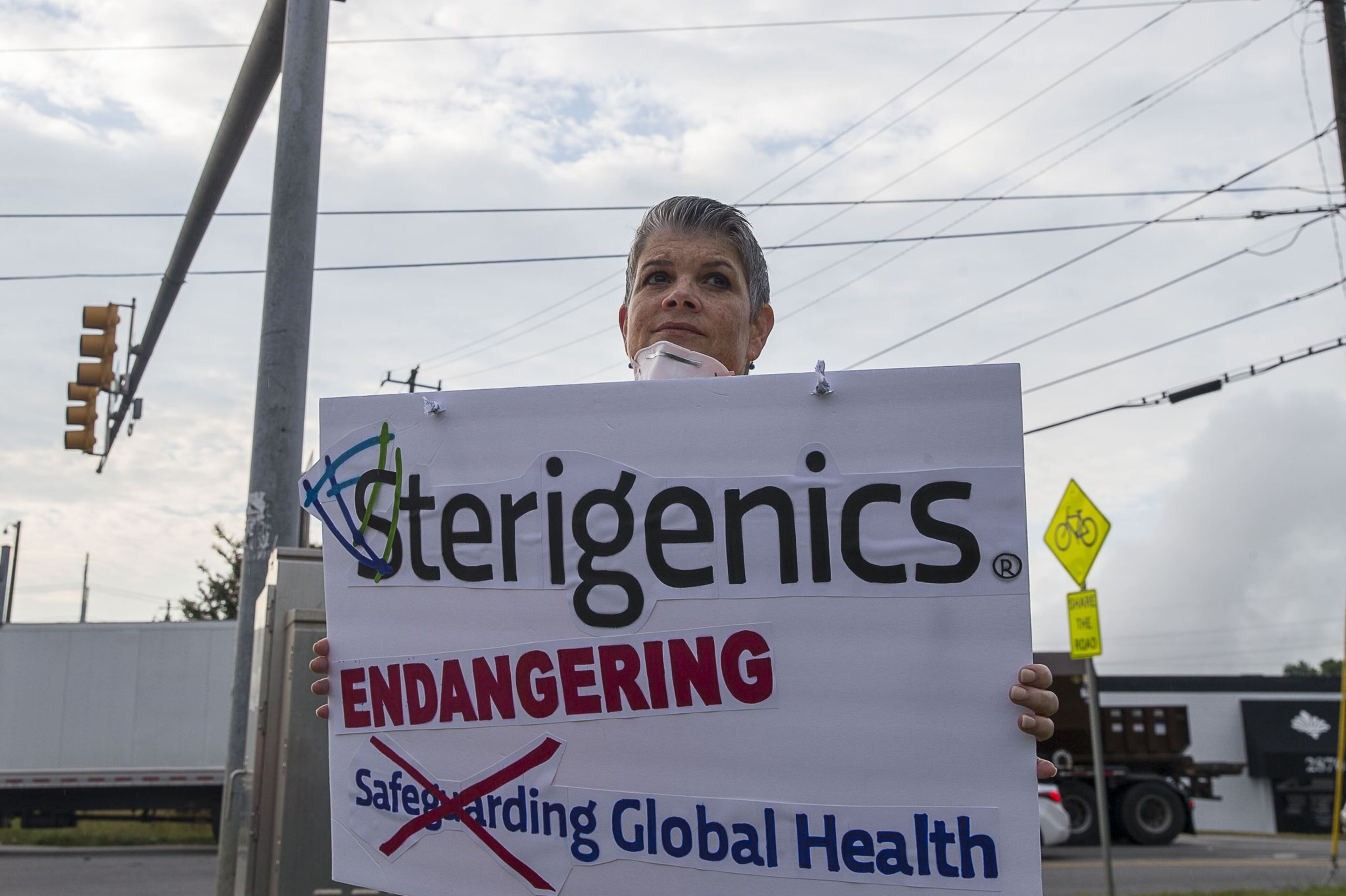 08/02/2019 — Smyrna, Georgia — Stop Sterigenics Georgia member Lynn Bixler holds a sign as she and other supporters protest against Sterigenics near the plant in Smyrna, Friday, August 2, 2019. Stop Sterigenics Georgia is an organization that is concerned about the Ethylene Oxide pollution that the Sterigenics plant is producing in the area. (Alyssa Pointer/alyssa.pointer@ajc.com)