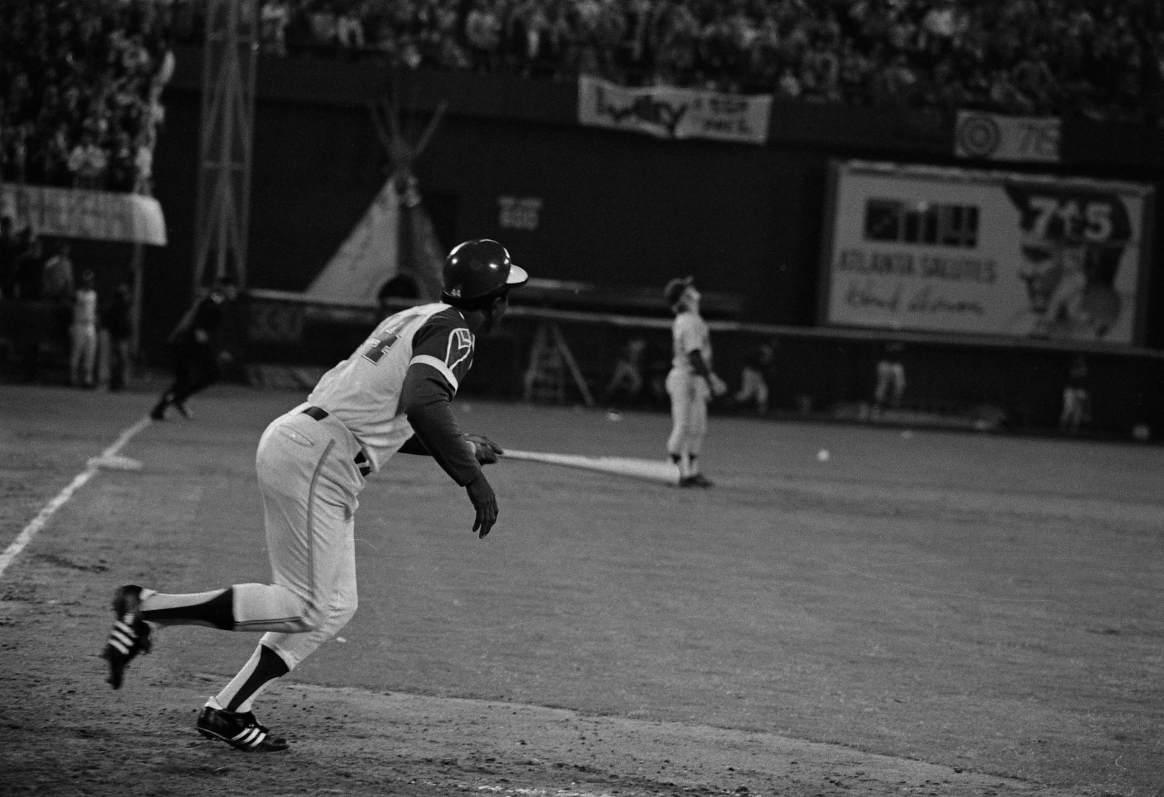 Hank Aaron heads toward first base as the ball sails over the fence. AJC file photo