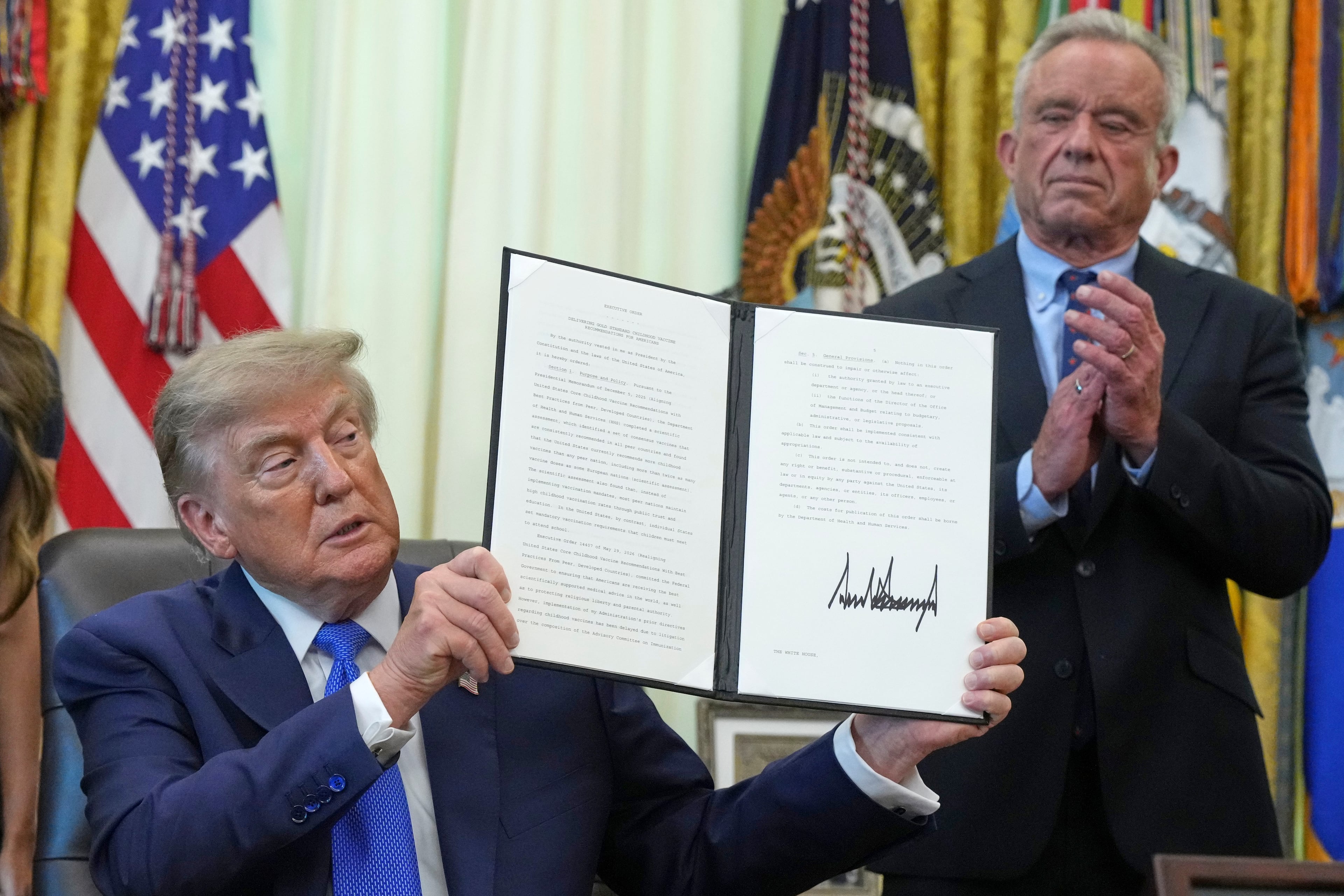 President Donald Trump signed an executive order about vaccines as Health and Human Services Secretary Robert F. Kennedy Jr. looks on, Monday, Aug. 10, 2026, at the White House. (Jacquelyn Martin/AP)