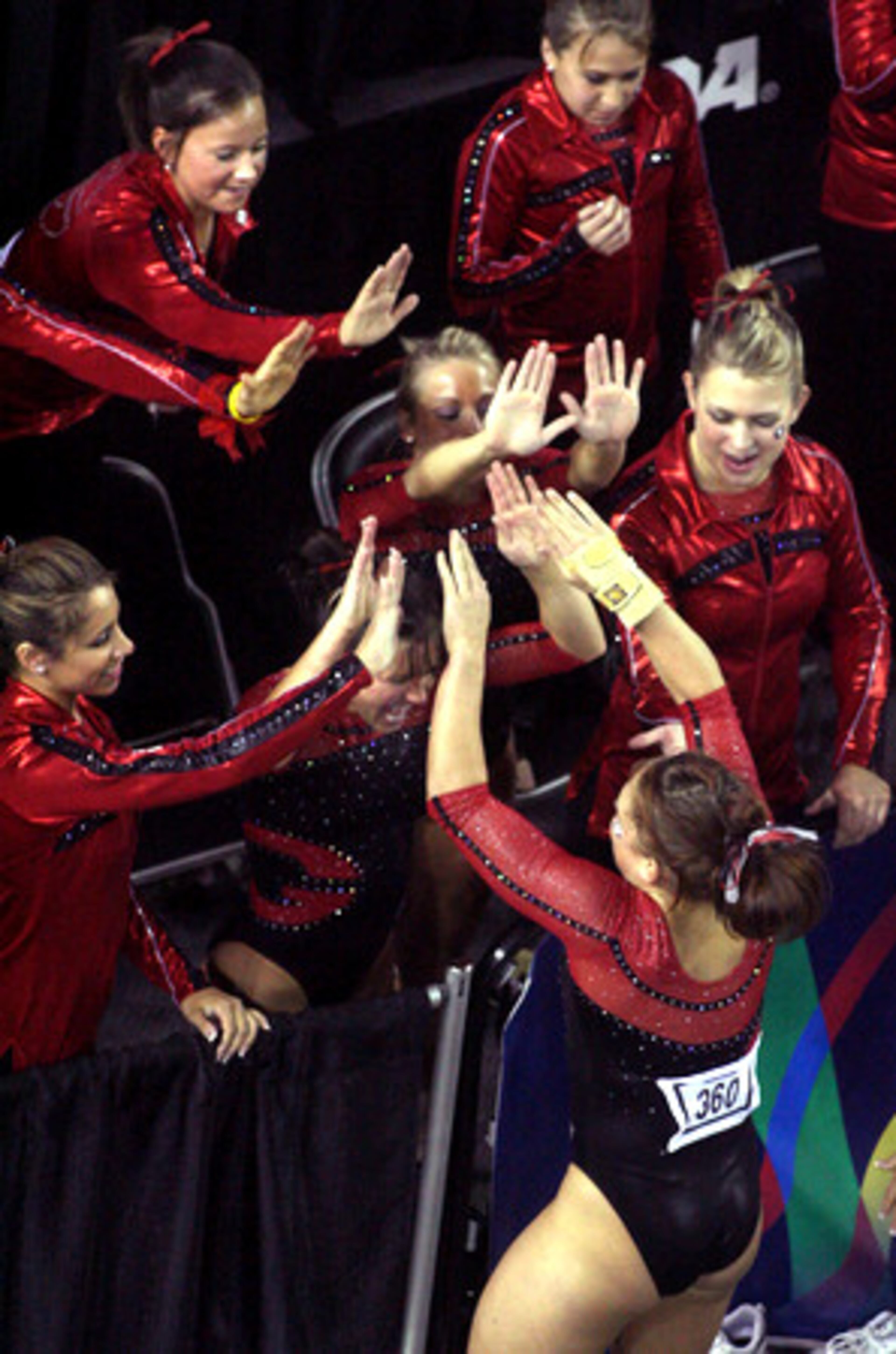 Georgia's Courtney McCool celebrates with teammates after she competed during Georgia's floor exercise during session II during the NCAA Gymnastics Championships Thursday night.