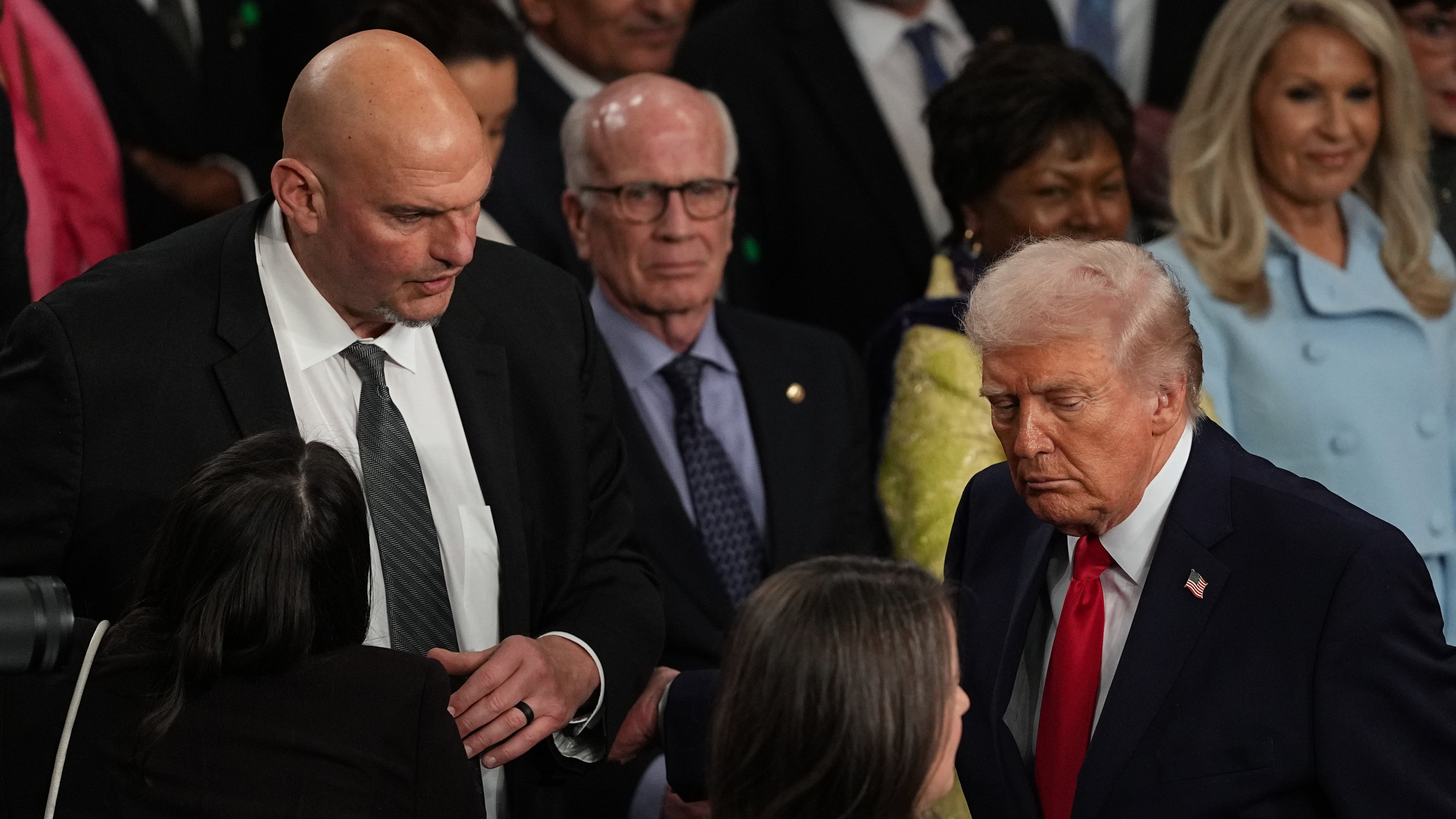 FILE - President Donald Trump passes Sen. John Fetterman, D-Pa., as he departs after delivering the State of the Union address to a joint session of Congress in the House chamber at the U.S. Capitol in Washington, Tuesday, Feb. 24, 2026. (AP Photo/Matt Rourke,File)