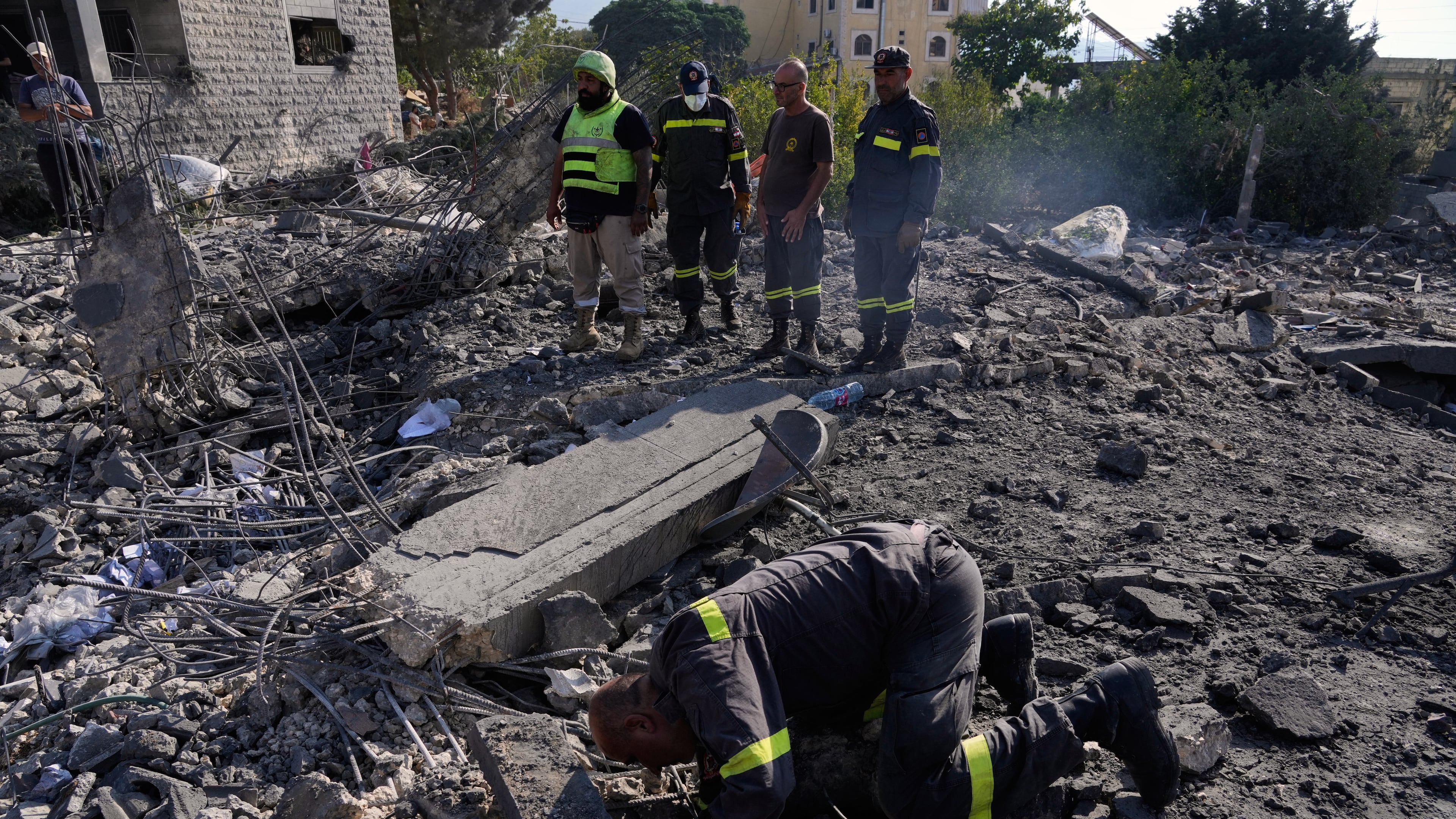 Rescue workers search for victims under the rubble of a building destroyed in an Israeli airstrike in the southern village of Kfar Rumman, Lebanon, Monday, Sept. 7, 2026. (AP Photo/Mohammed Zaatari)