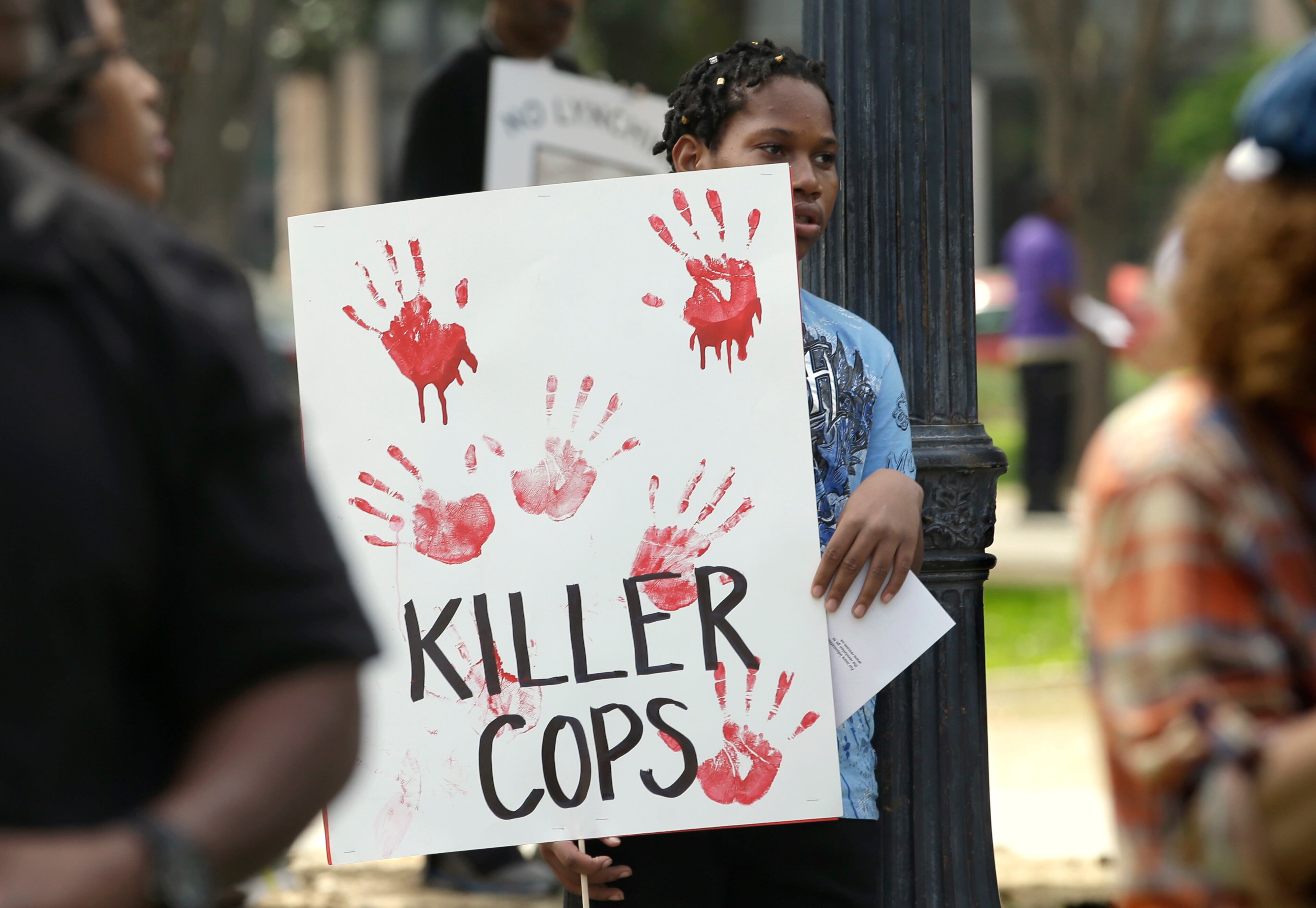 Jalil Taylor, 13, holds a sign as he joins others at a rally aimed at ensuring the memory of police shooting victim Stephon Clark and calling for police reform, Saturday, March 31, 2018, in Sacramento, Calif. The gathering comes nearly two weeks after Clark, who was unarmed, was shot and killed by two Sacramento police officers. (AP Photo/Rich Pedroncelli)