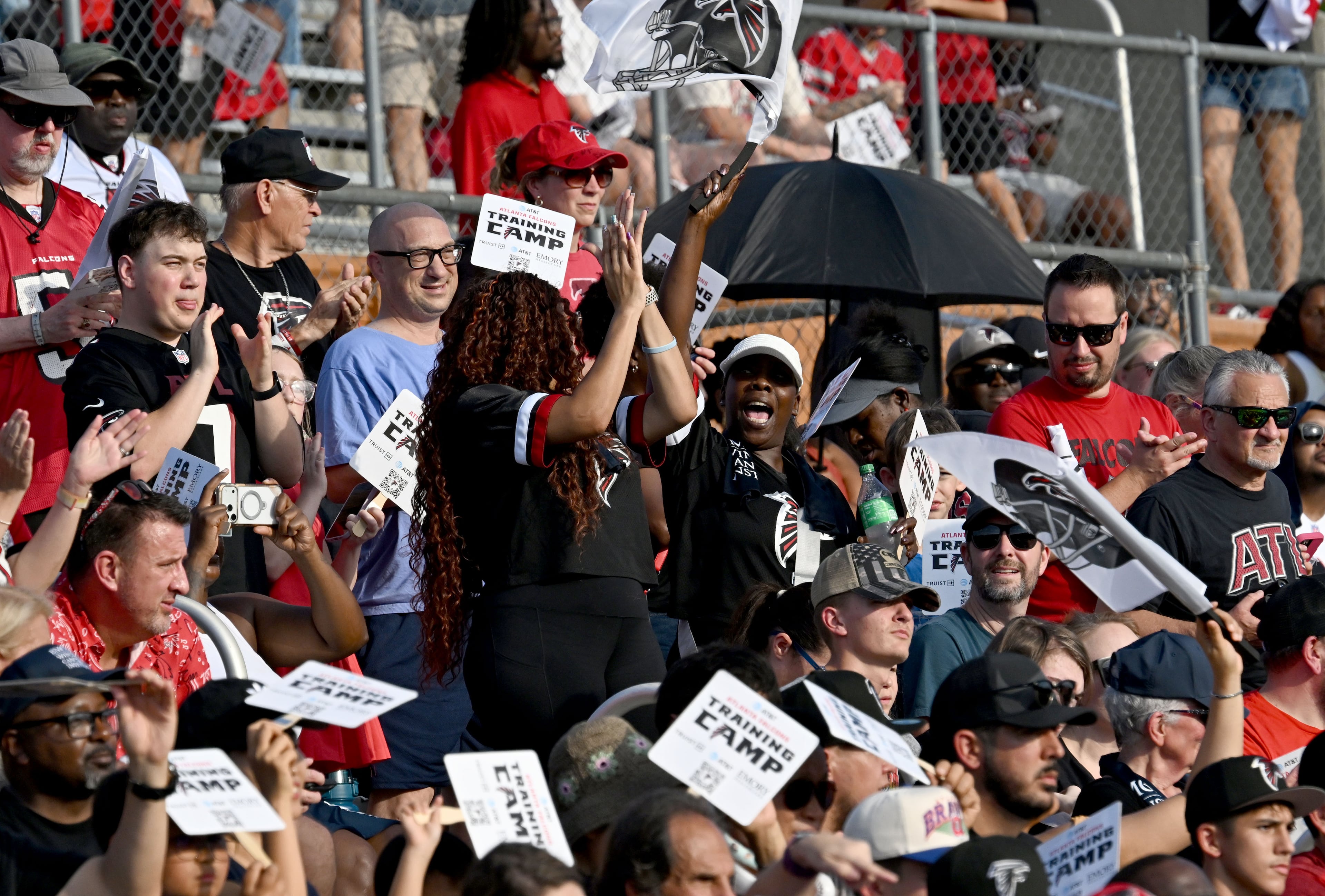 Football fans cheer as they watch their favorite players in action during the Atlanta Falcons' "Saturday Night Lights" practice Saturday, Aug. 8, 2026, at Lanier High School in Sugar Hill. (Hyosub Shin/AJC)
