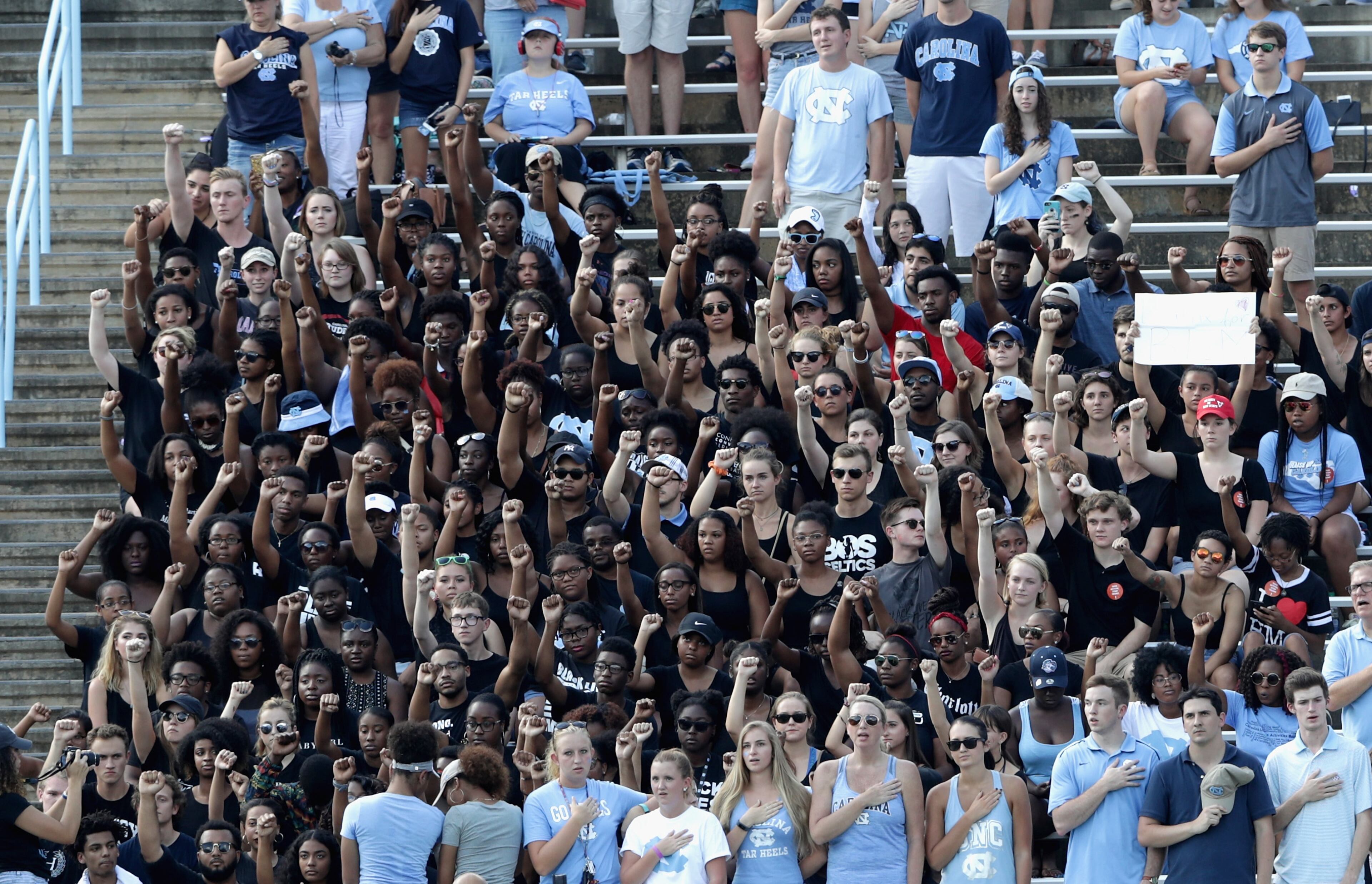 Students protest during the national anthem before the start of the Pittsburgh Panthers and North Carolina Tar Heels game at Kenan Stadium on September 24, 2016 in Chapel Hill, North Carolina. Players for Michigan and Michigan State raised their fists during the playing of the Star Spangled Banner at their games too. Click here to read more.(Photo by Streeter Lecka/Getty Images)