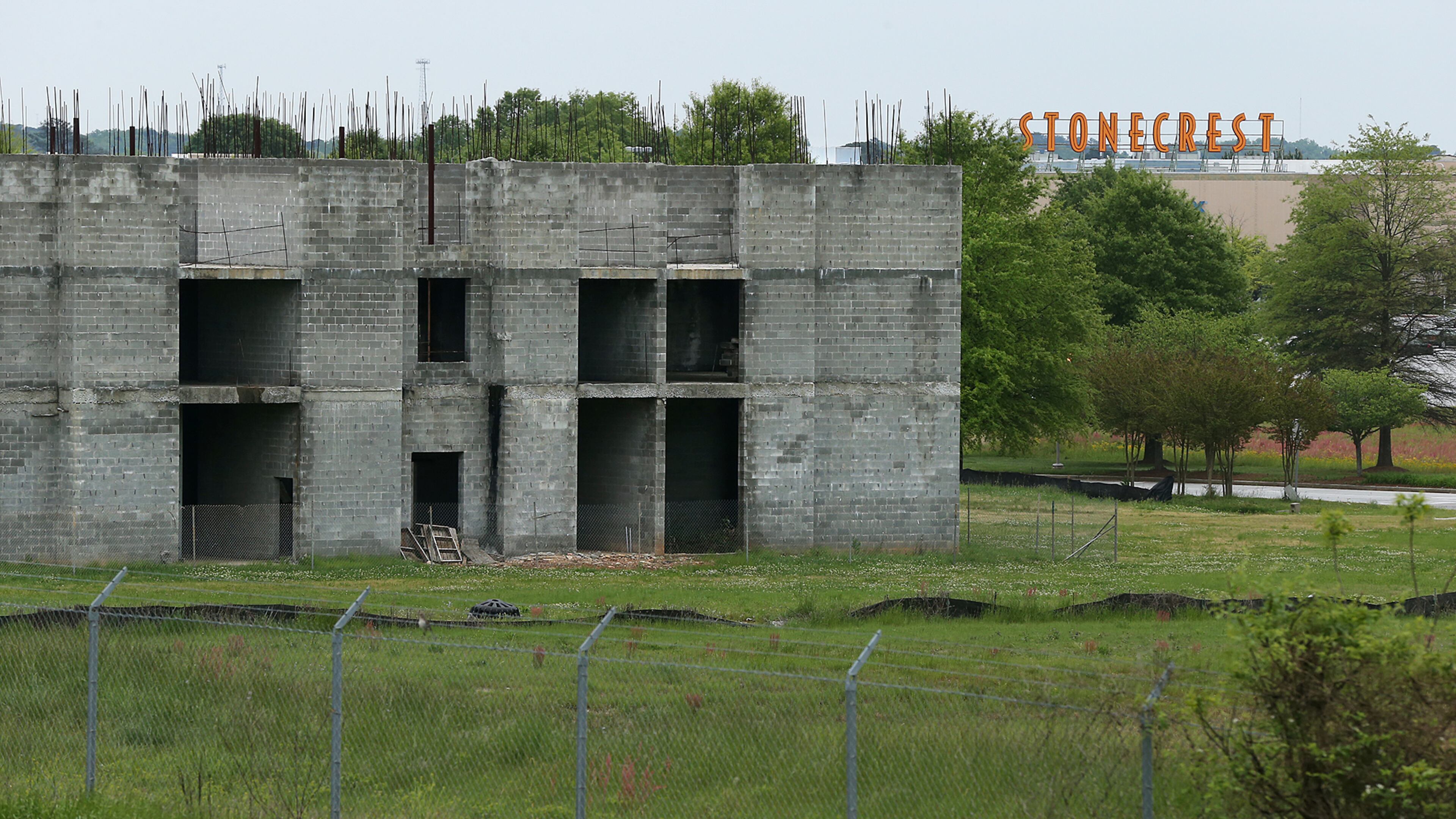 The cinderblock shell of a hotel that was supposed to be finished a decade ago sits a stone’s throw from Stonecrest Mall as a testament to the increasing vacancy of stores around the mall and the challenges facing suburban shopping centers on Wednesday, April 13, 2016. Curtis Compton / ccompton@ajc.com