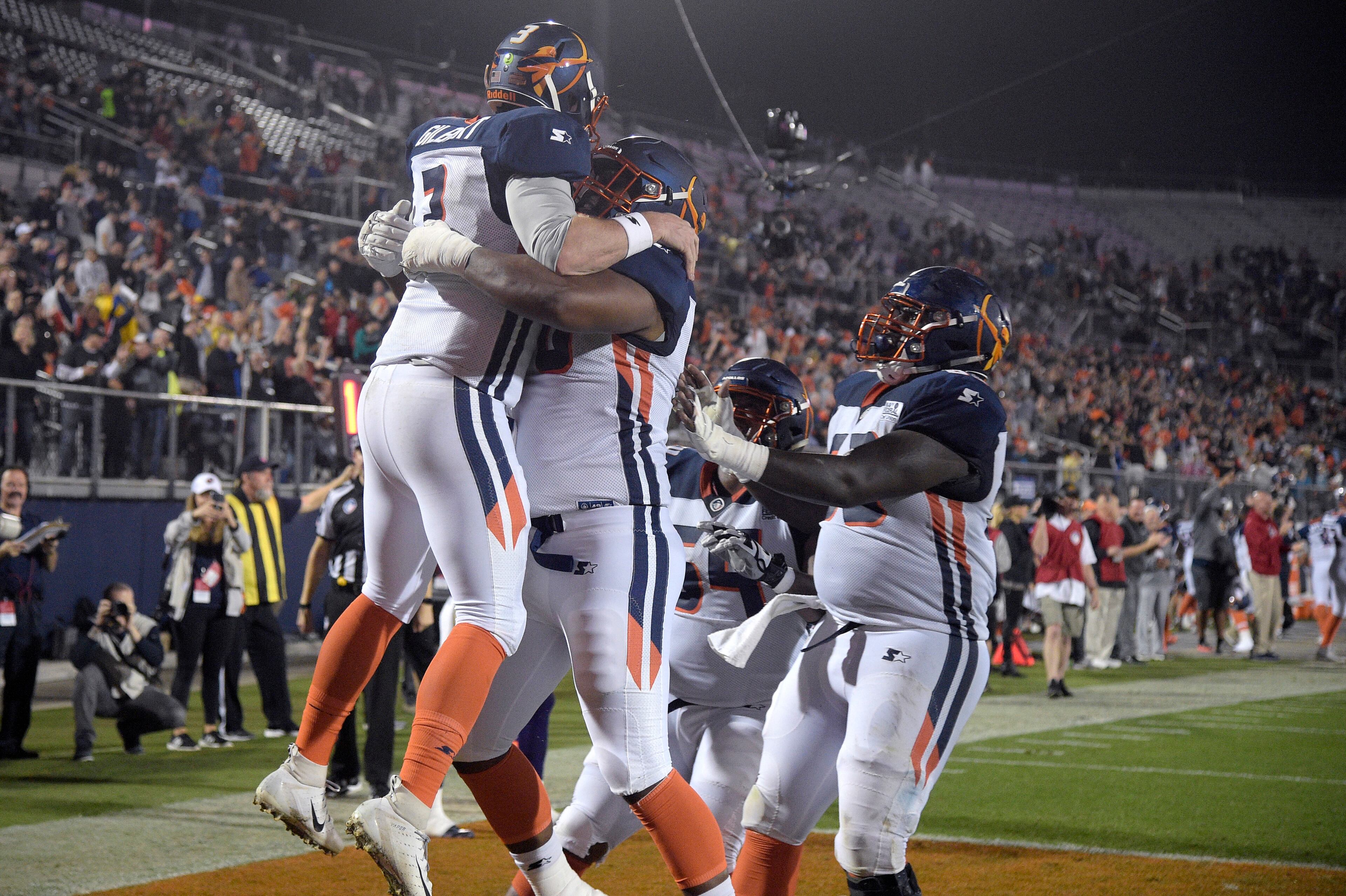 Orlando Apollos quarterback Garrett Gilbert, left, is congratulated by teammates after catching a pass from receiver Jalin Marshall for a 5-yard touchdown during the first half of an Alliance of American Ffootball game against the Atlanta Legends on Saturday, Feb. 9, 2019, in Orlando, Fla. (AP Photo/Phelan M. Ebenhack)