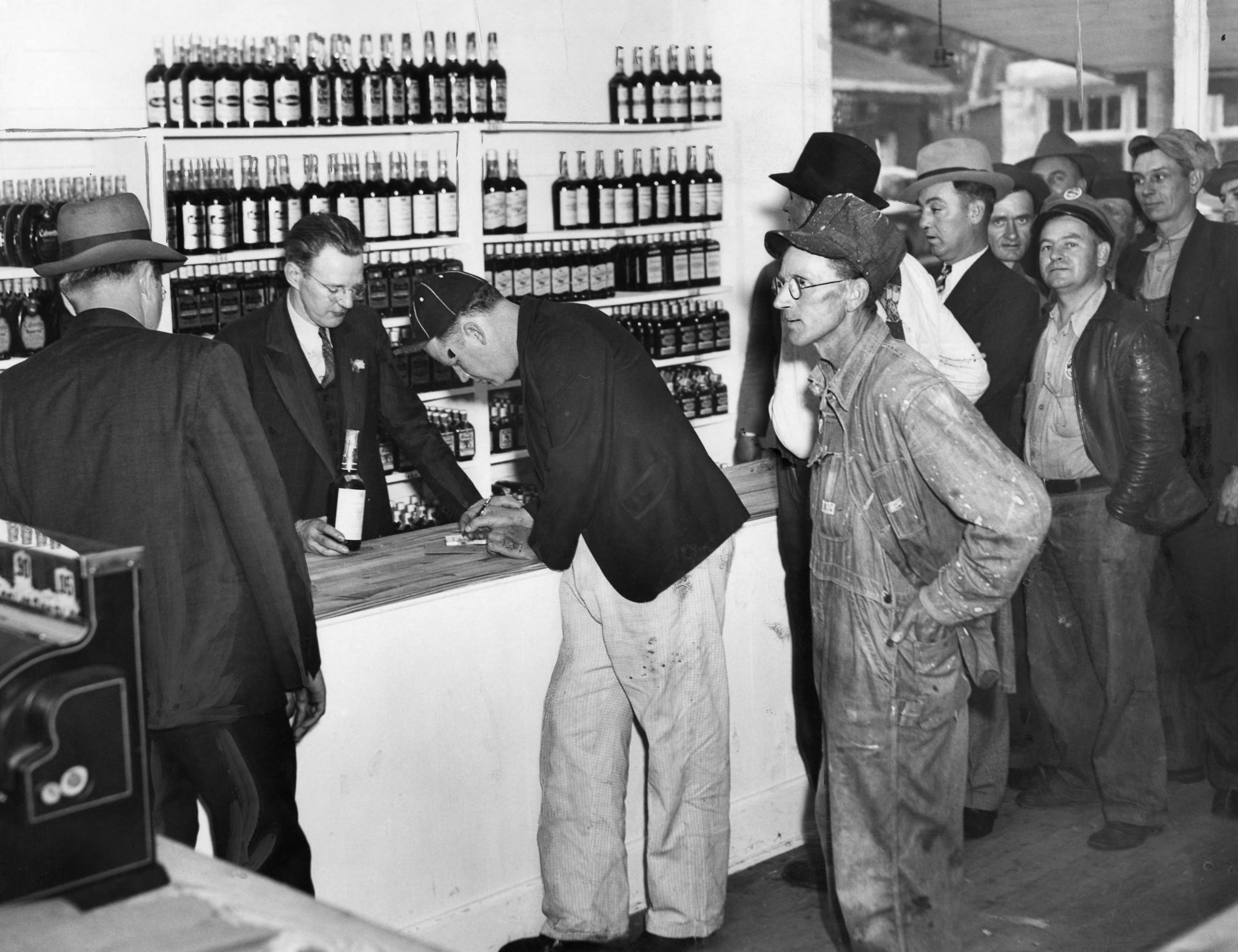 From original caption, published April 22, 1938: "Legal liquor comes to Cobb County: First legal liquor sale in Cobb County in 54 years was made in this 12x14 concrete block building Thursday afternoon. Built especially as a liquor store, the small structure stands next to the Smyrna City Hall. B. F. Reed, Jr., the proprietor, is in the doorway as a group of curious look on. The second Smyrna liquor store faces this one from across the highway."