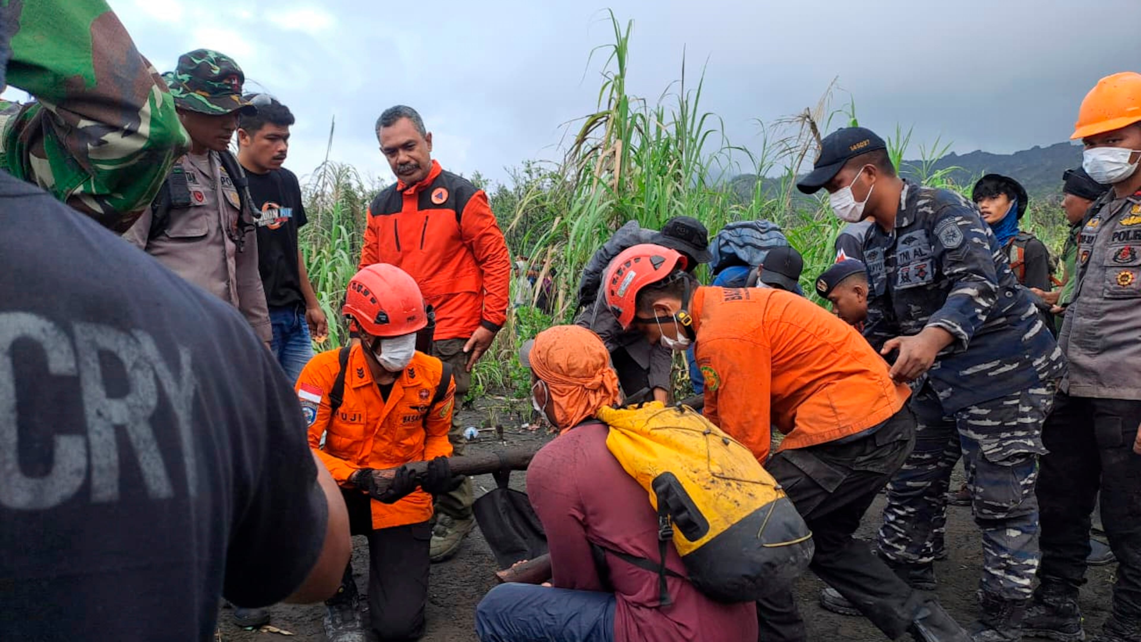 In this photo released by the Indonesian National Search and Rescue Agency (BASARNAS) rescuers carry the body of a victim of the eruption of Mount Dukono, on Halmahera Island, Indonesia, Saturday, May 9, 2026. (BASARNAS via AP)