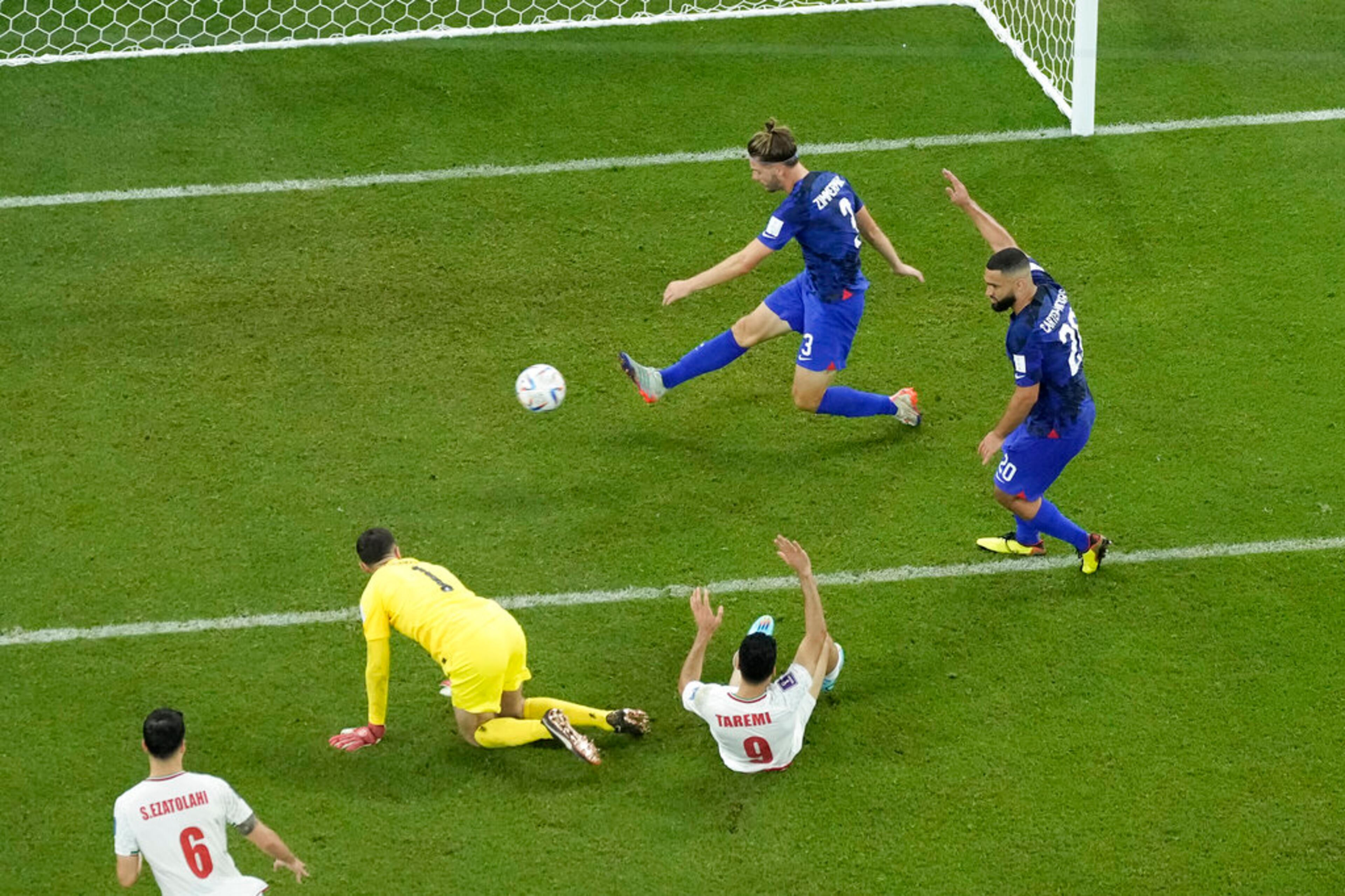 Walker Zimmerman of the United States, top, scleras the ball away to stop a goal from Iran's Mehdi Taremi, on the ground, in the last minutes of the World Cup group B soccer match between Iran and the United States at the Al Thumama Stadium in Doha, Qatar, Wednesday, Nov. 30, 2022. (AP Photo/Hassan Ammar)