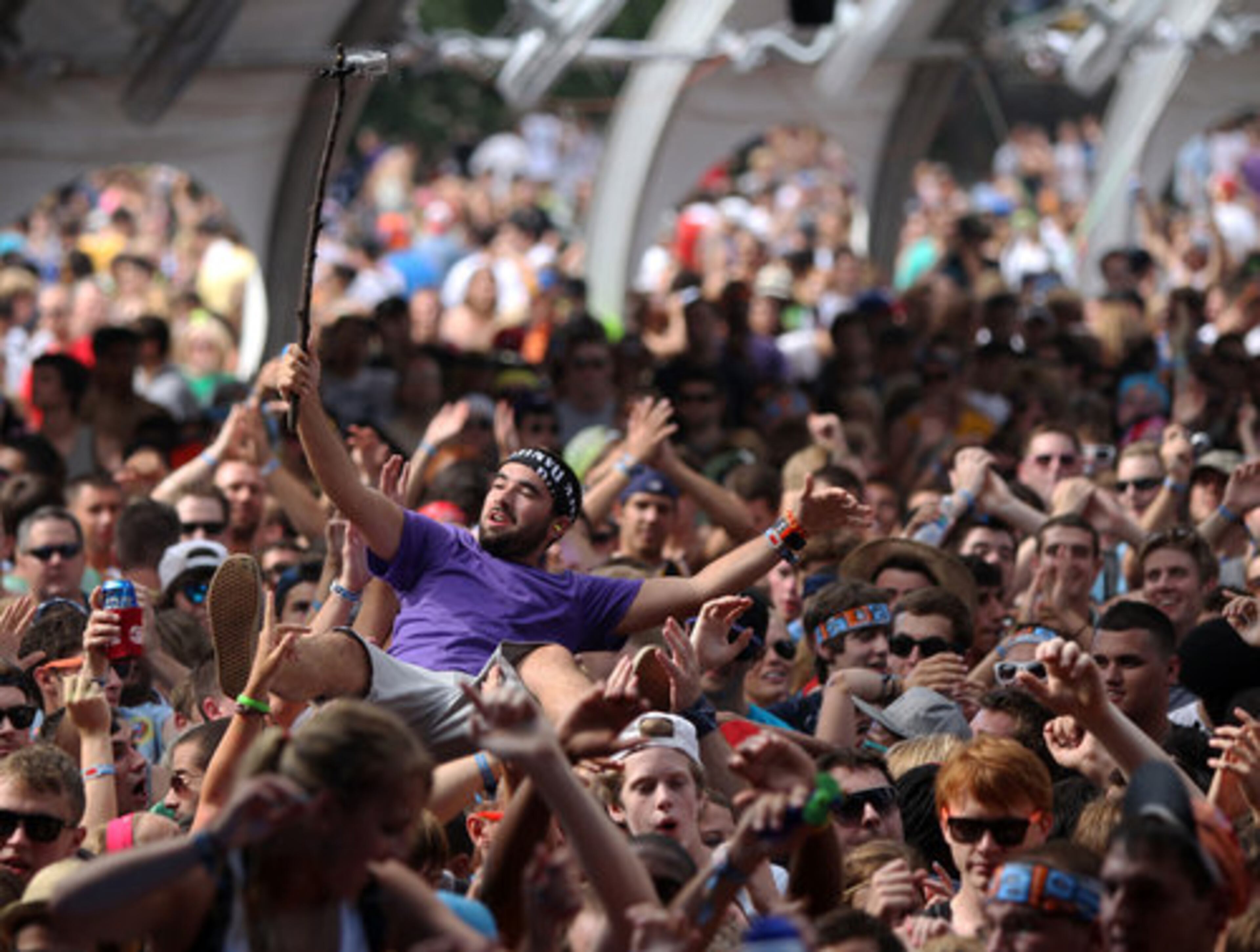 A crowd surfing fan records the moment with a camera attached to a stick during a set by Perry Farrell at Lollapooza in Chicago, Illinois, Saturday, August 6, 2011.
