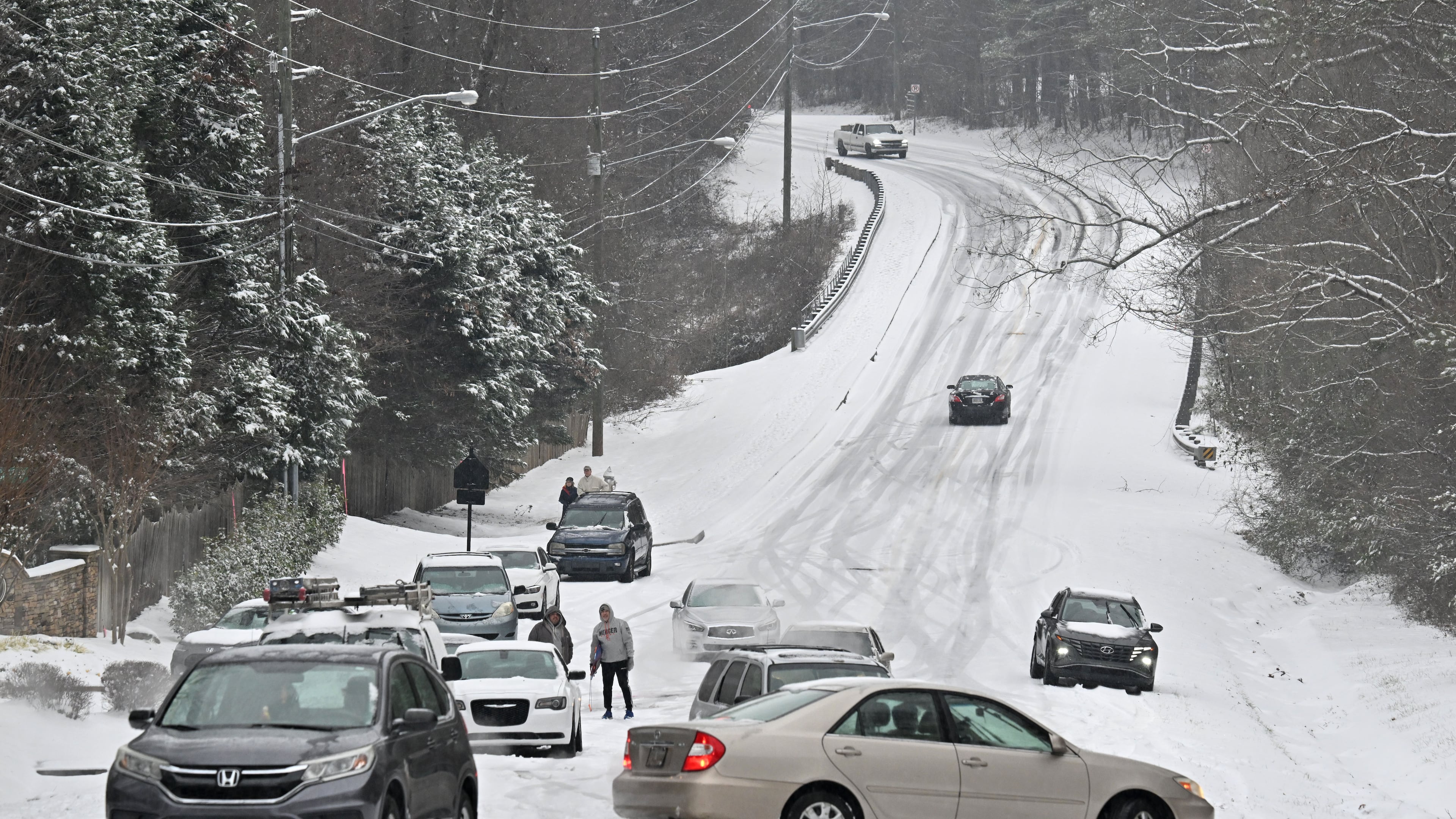 Vehicles get stuck in the snow on Old Snellville Highway on Friday, Jan. 10, 2025, in Lawrenceville. Georgia is bracing for a possibly significant winter storm expected this weekend. (Hyosub Shin/AJC)