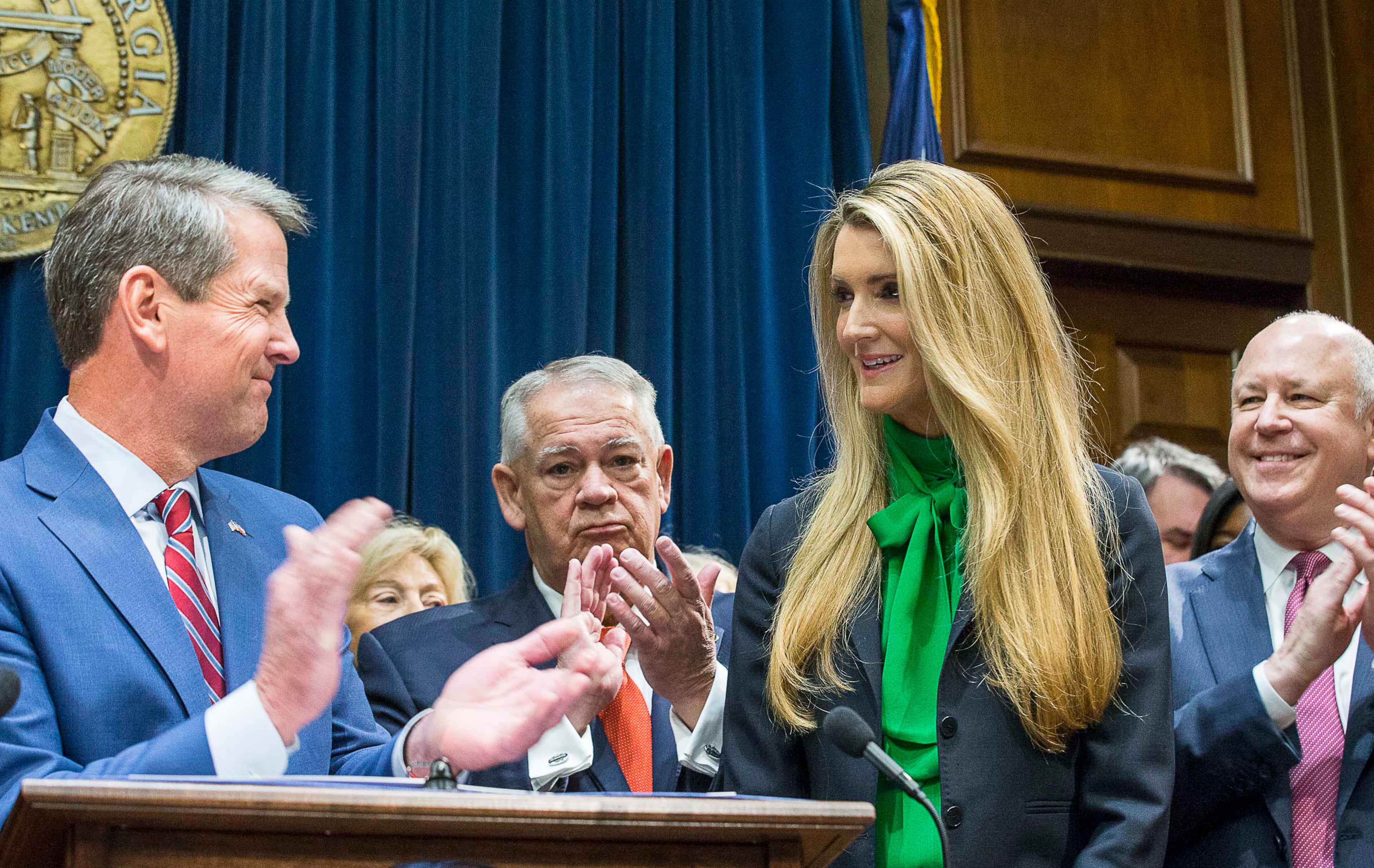 Lawmakers applaud as newly appointed U.S. Sen. Kelly Loeffler, second from right, is introduced by Georgia Gov. Bria Kemp, left, during a news conference in 2019. Loeffler would later lose to Democrat Raphael Warnock in a runoff. (Alyssa Pointer/AJC)