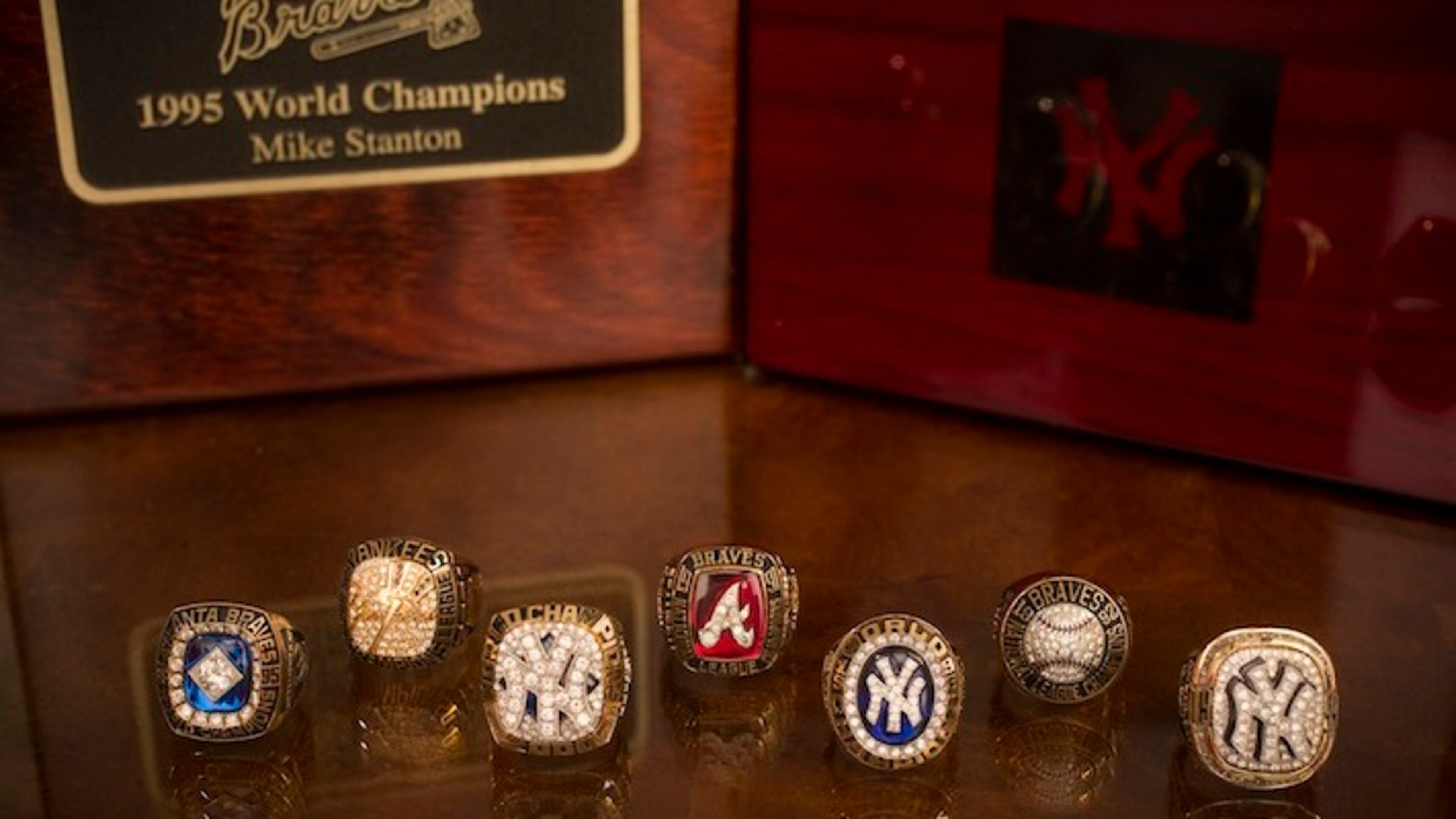 Former Major League Baseball pitcher Mike Stanton's seven championship rings from his years with the Atlanta Braves and New York Yankees: four World Series Champions rings in front and three American League Champions rings in back, in Montgomery, Texas, Nov. 24, 2015. It is unclear when the practice started, but Major League Baselball teams that lose the World Series often buy themselves rings for winning their league's pennant. (Michael Stravato/The New York Times)