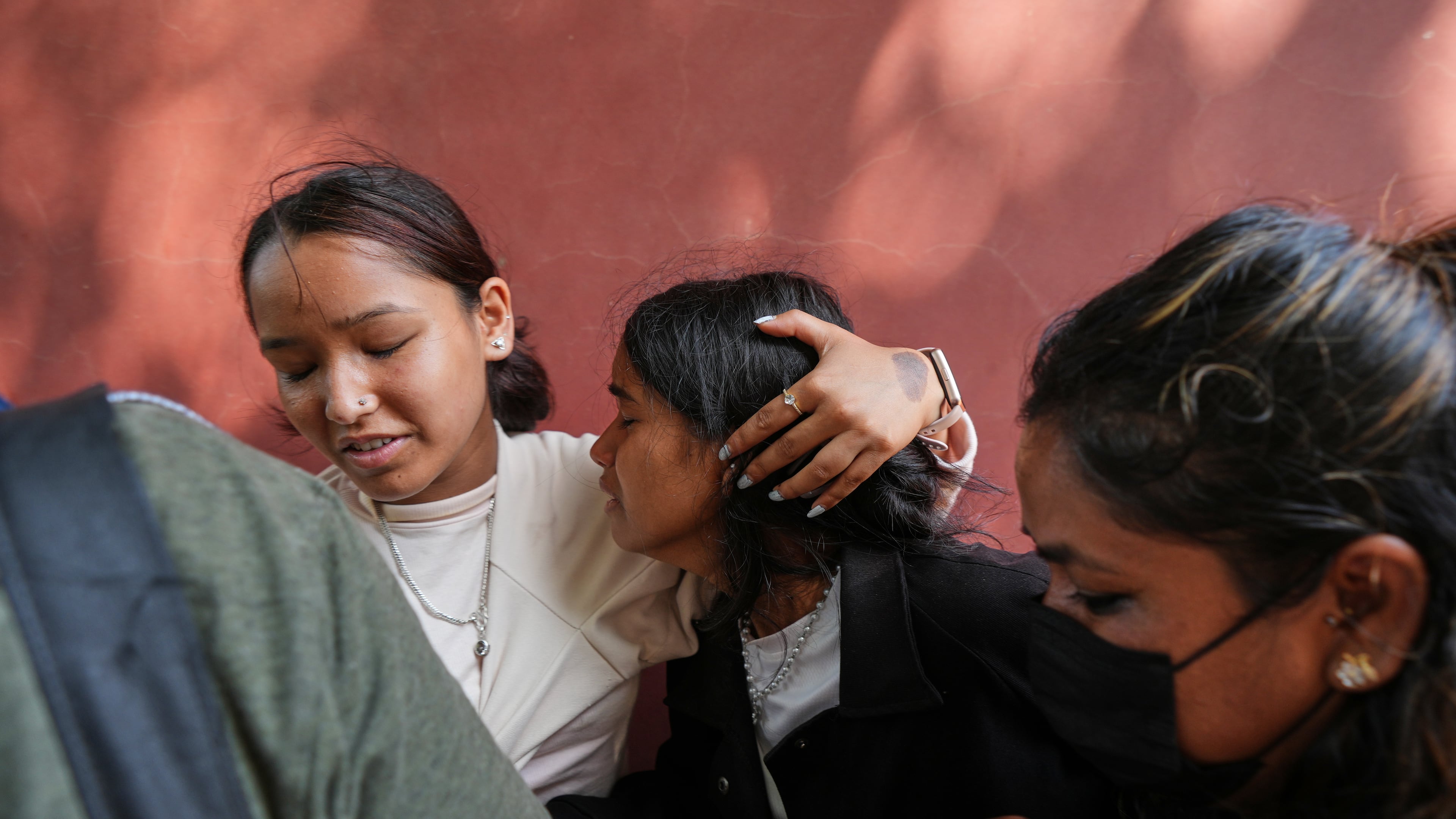 A relative consoles Jenisha, center, as she cries while waiting for the news of her father missing after flash flooding in Nepal's Nuwakot district, Friday, Aug. 28, 2026. (AP Photo/Rajesh Kumar Singh)