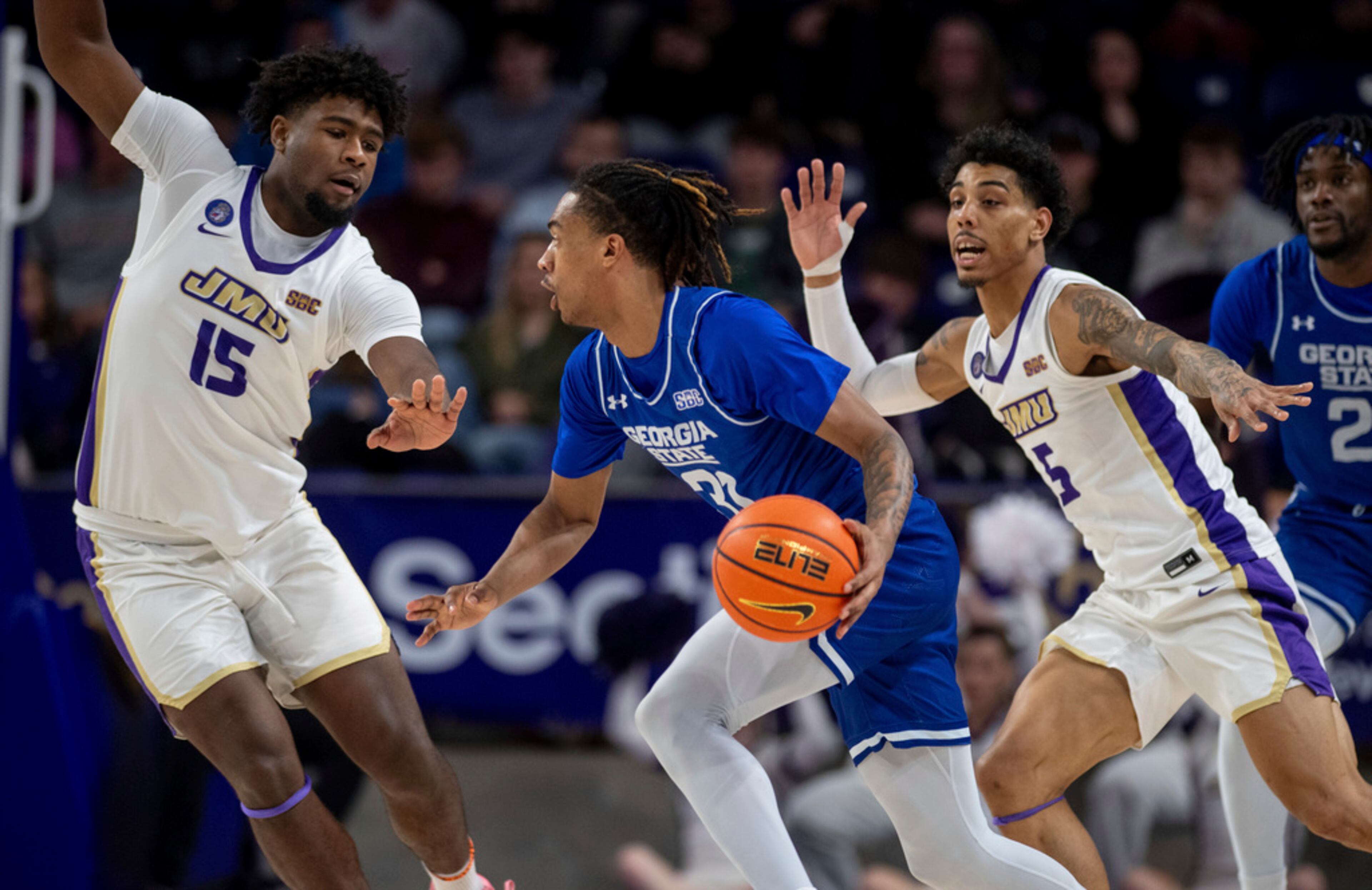 Georgia State guard Lucas Taylor (31) drives against James Madison forward Jaylen Carey (15) and guard Terrence Edwards Jr. (5) during the second half of an NCAA college basketball game in Harrisonburg, Va., Thursday, Feb. 15, 2024. (Daniel Lin/Daily News-Record via AP)