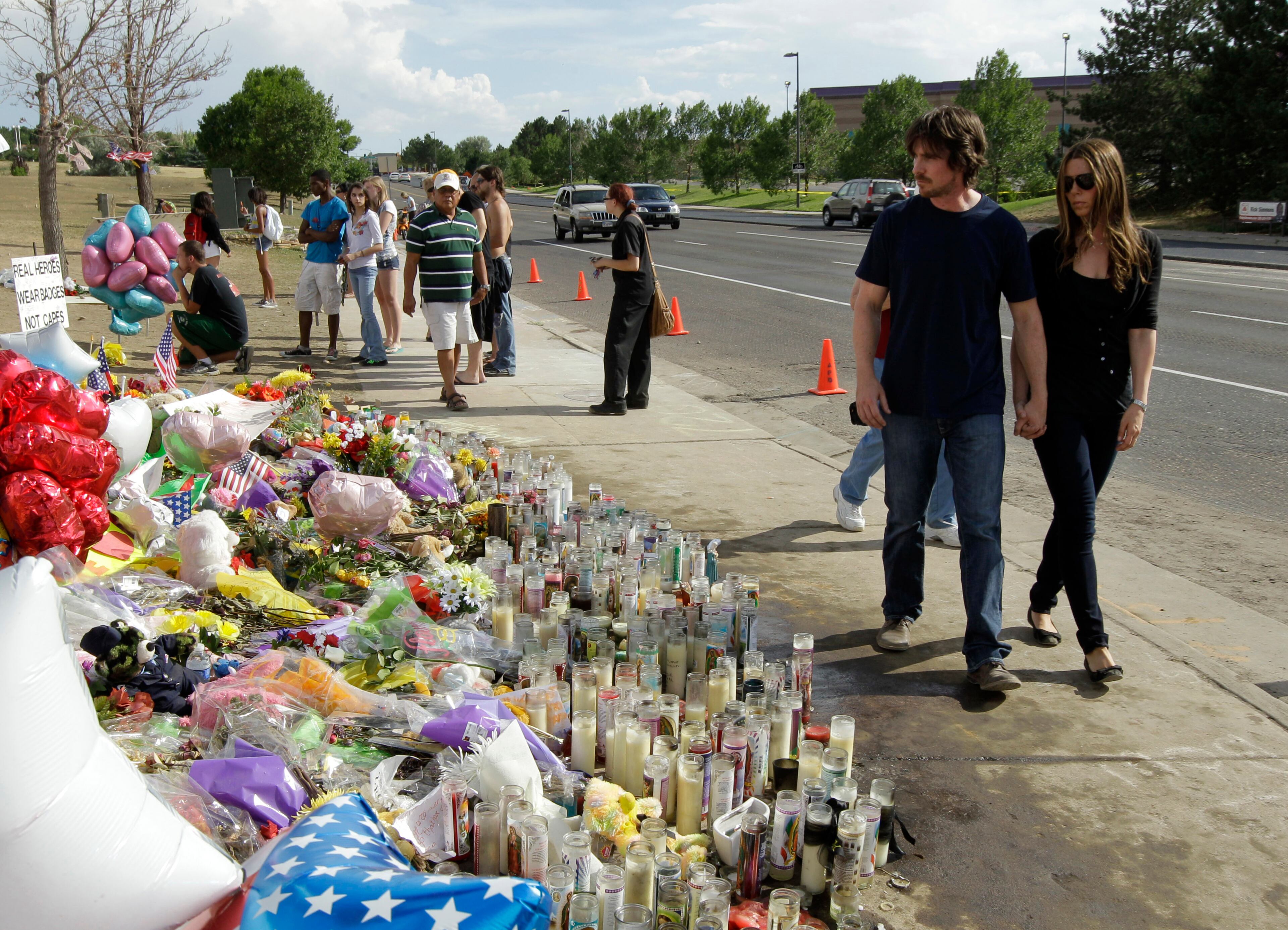 Actor Christian Bale, second right, and his wife Sibi Blazic, right, visit a memorial to the victims of Friday's mass shooting, Tuesday, July 24, 2012, in Aurora, Colo. Twelve people were killed when a gunman opened fire during a late-night showing of the movie Dark Knight Rises, which stars Bale as Batman. (AP Photo/Ted S. Warren)