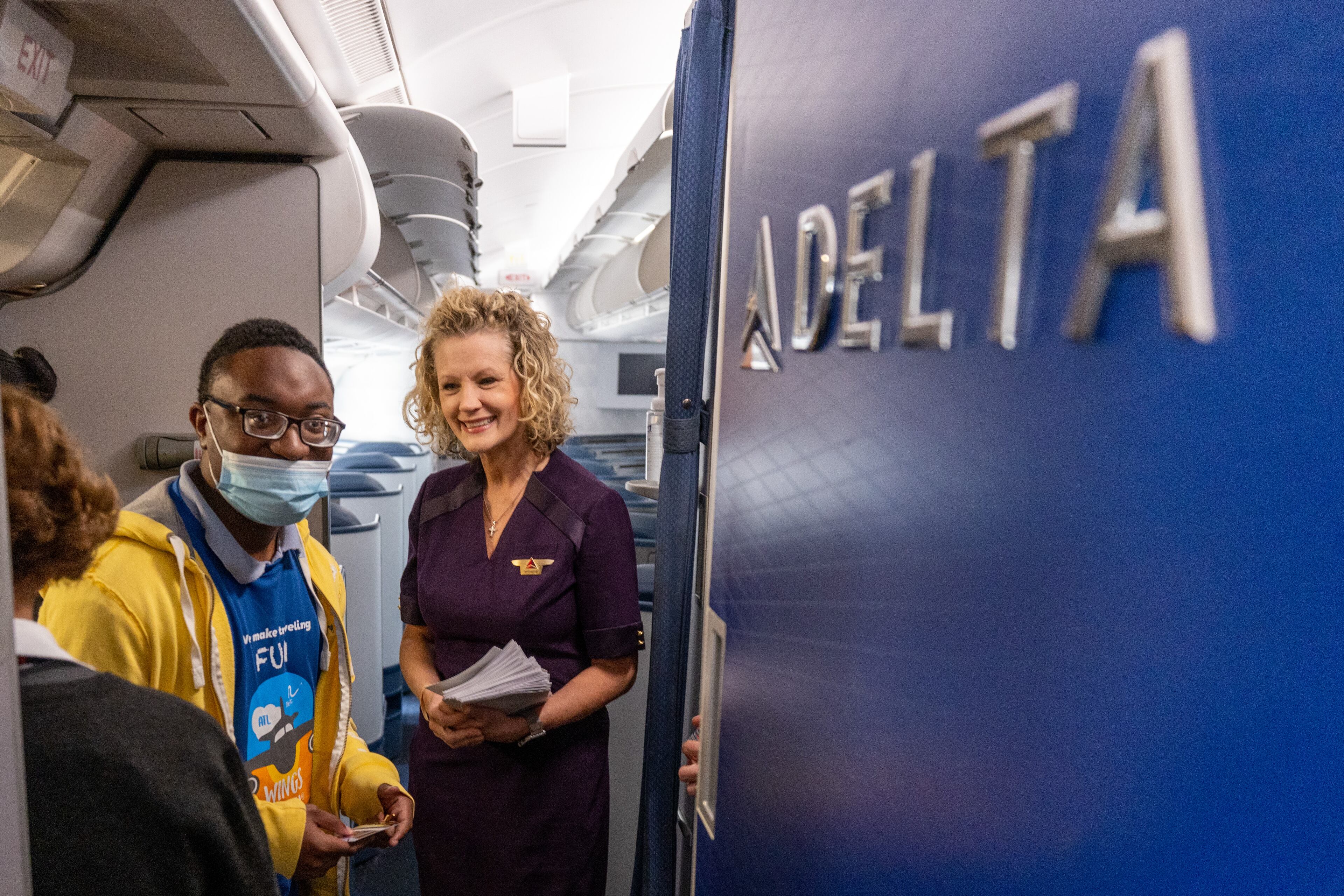 Participants walk onto a Delta Air Lines jet during A Wings For All event at the Hartsfield-Jackson Atlanta International Airport Tuesday, April 11, 2023. (Steve Schaefer/steve.schaefer@ajc.com)