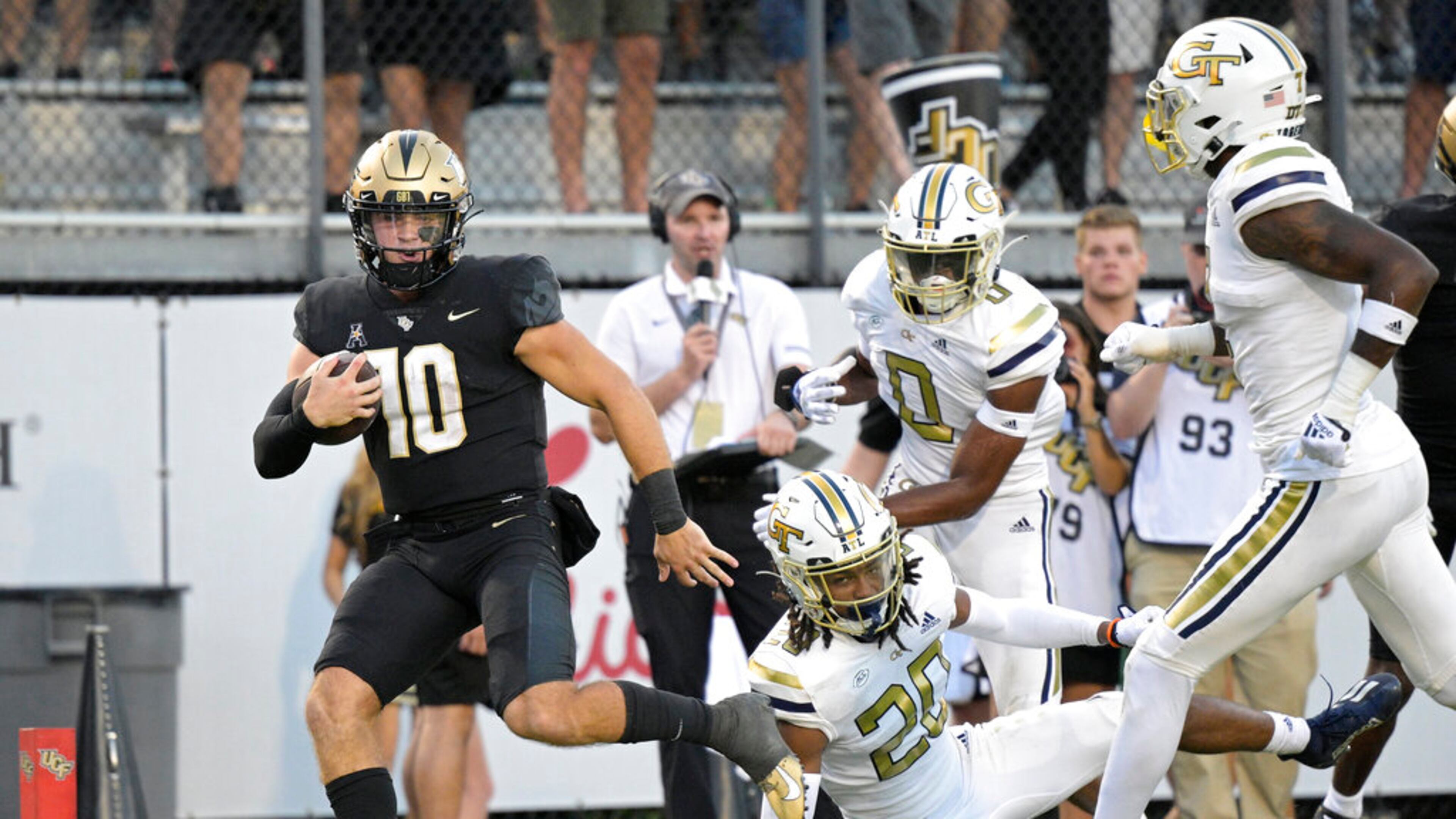 Central Florida quarterback John Rhys Plumlee (10) rushes for a 28-yard touchdown past Georgia Tech defensive backs LaMiles Brooks (20), Myles Sims (0) and Zamari Walton, right, during the second half of an NCAA college football game, Saturday, Sept. 24, 2022, in Orlando, Fla. (AP Photo/Phelan M. Ebenhack)