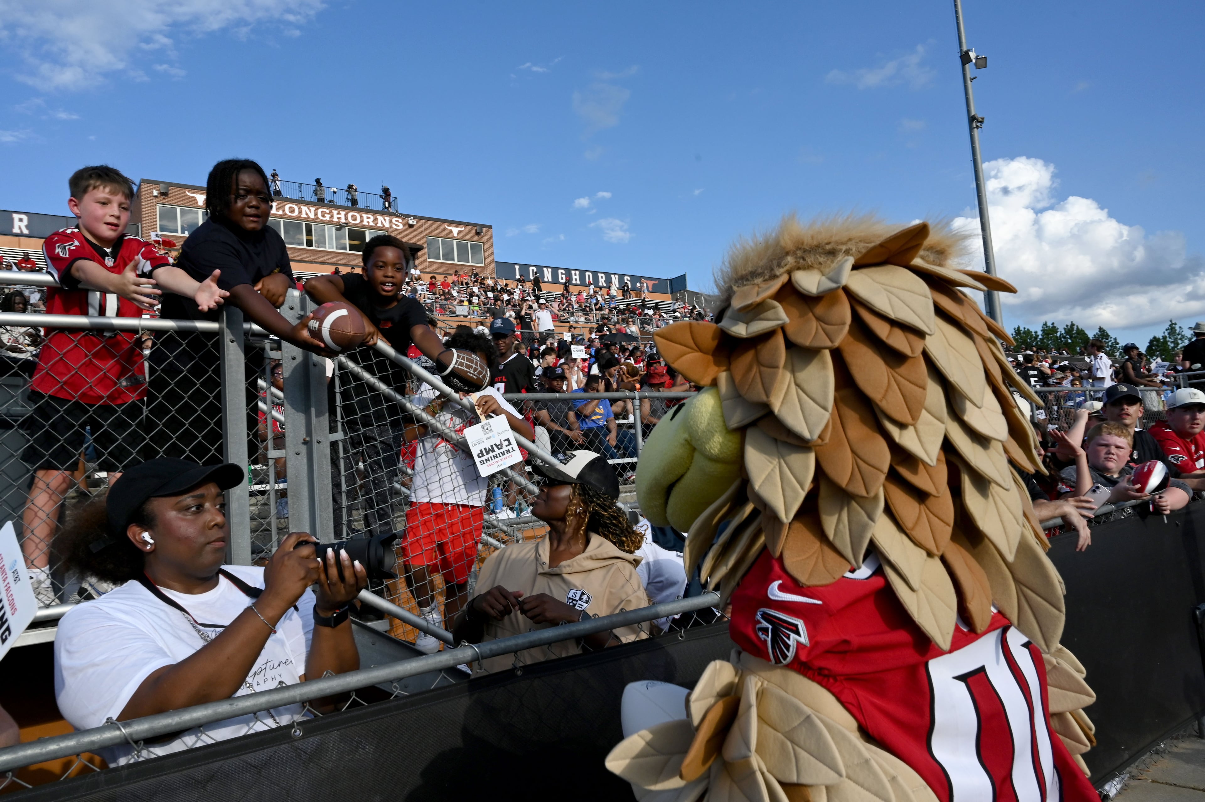 Freddie Falcon signs autographs for fans during the Falcons' "Saturday Night Lights" practice Saturday, Aug. 8, 2026, at Lanier High School in Sugar Hill. (Hyosub Shin/AJC)