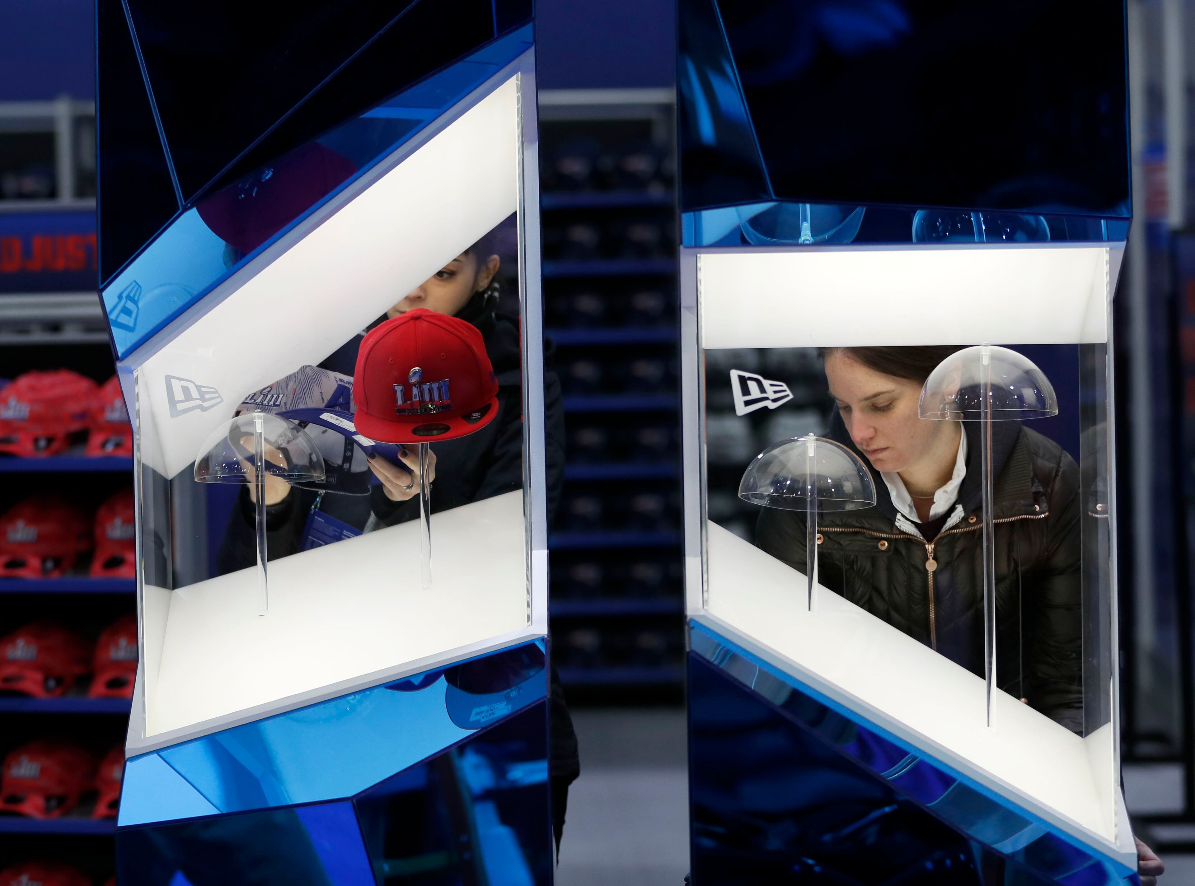 1/25/19 - Atlanta - Nicole Nuchereno (left) and Tara O'Rourke set up a hat display in the NFL Shop in the Super Bowl Experience. Crews work to get Super Bowl LIII's official fan attractions, Super Bowl LIVE presented by Verizon, Super Bowl Experience Driven by Hyundai and NFL Shop at Super Bowl LIII presented by Visa, ready for opening day on Saturday. Bob Andres / bandres@ajc.com