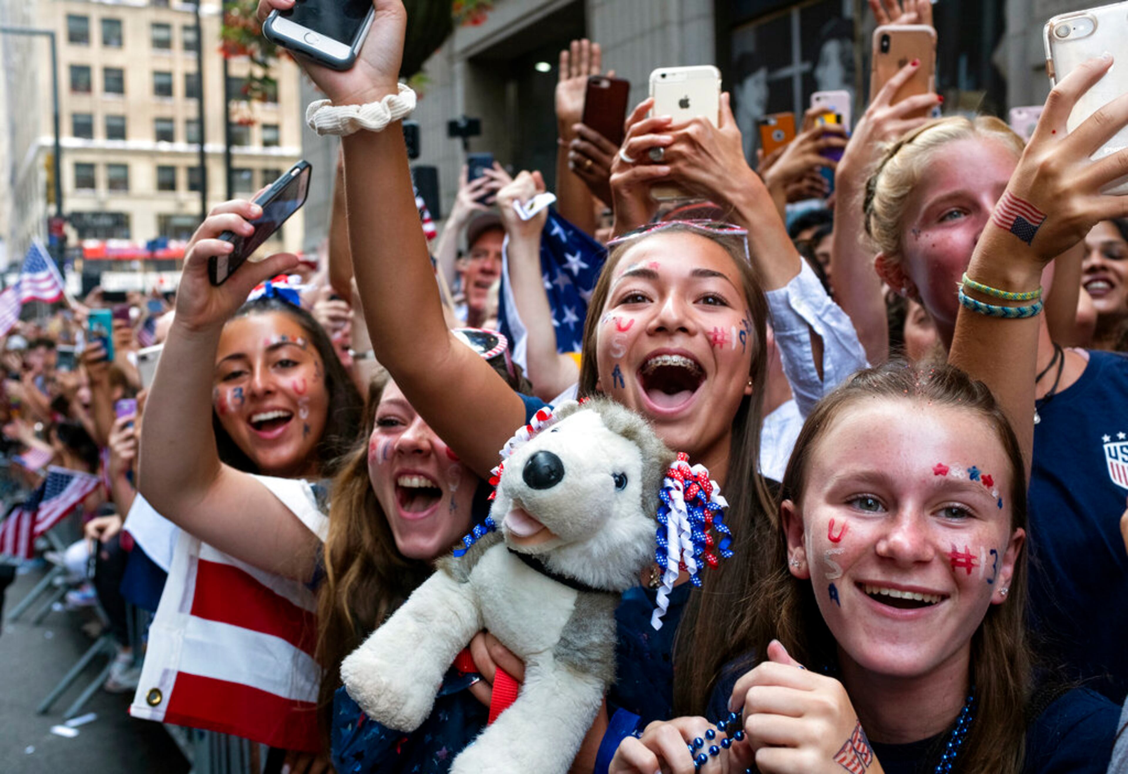Fans celebrates as members of the the U.S. women's soccer team pass by during a ticker tape parade along the Canyon of Heroes, Wednesday, July 10, 2019, in New York. The U.S. national team beat the Netherlands 2-0 to capture a record fourth Women's World Cup title.(AP Photo/Craig Ruttle)