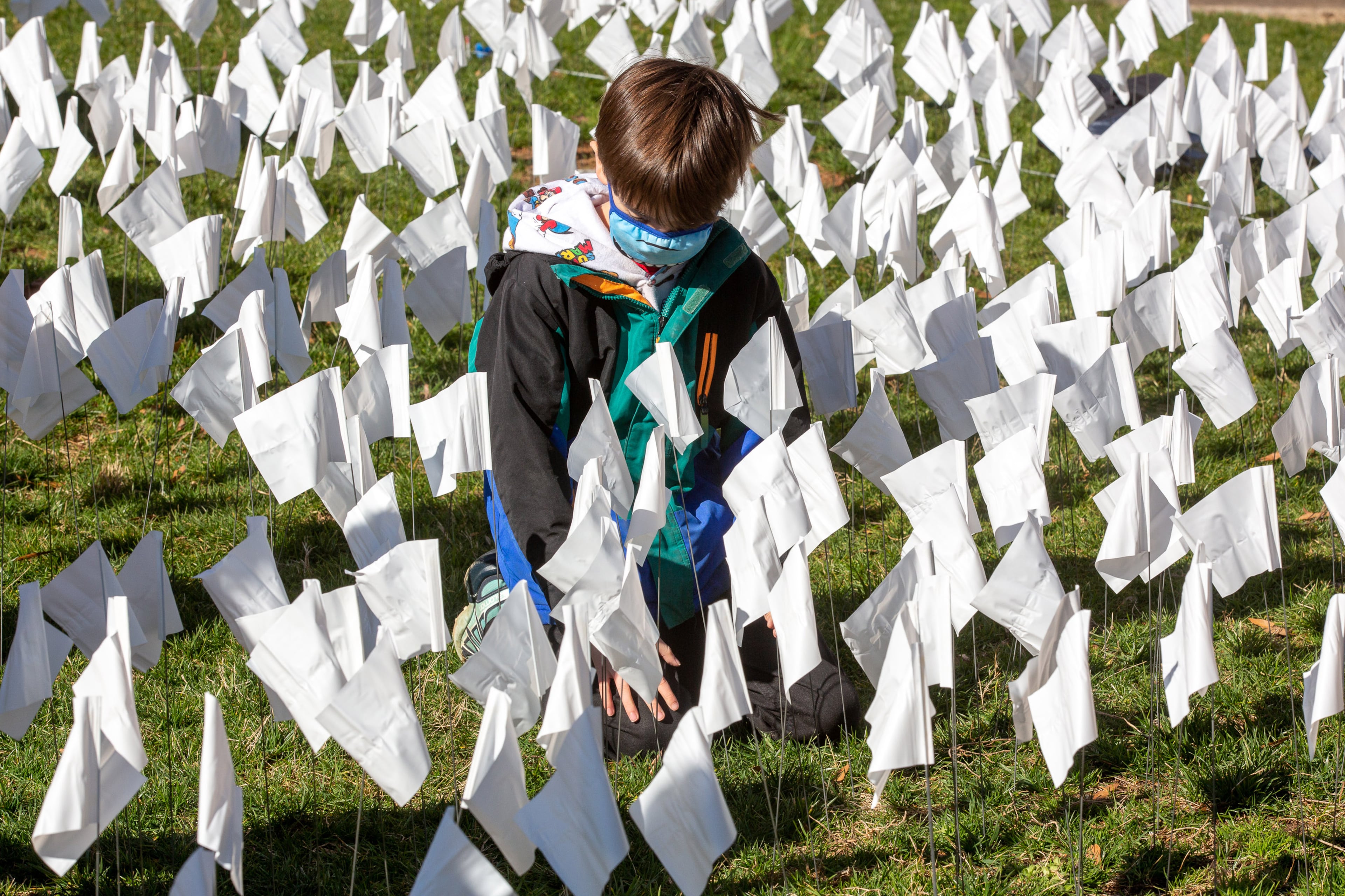 Lucian Hargrove, 8, helps plant some of the 15,000 flags on the lawn of First Christian Church of Decatur on Saturday, February 20, 2021. The flags represent the number of COVID-19 deaths in Georgia, and the effort aims to raise awareness about the toll of the coronavirus. (Photo: Steve Schaefer for The Atlanta Journal-Constitution)