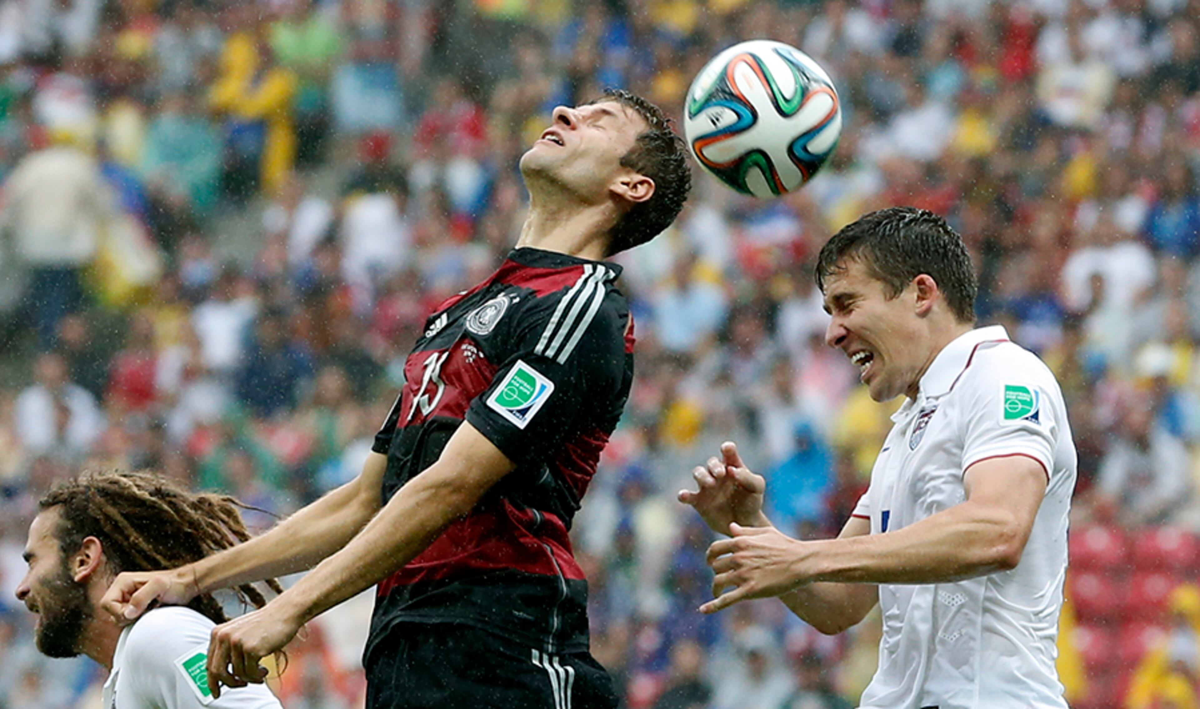 Germany's Thomas Mueller and United States' Matt Besler (right) go for a header during the group G World Cup soccer match between the USA and Germany at the Arena Pernambuco in Recife, Brazil, Thursday, June 26, 2014.
