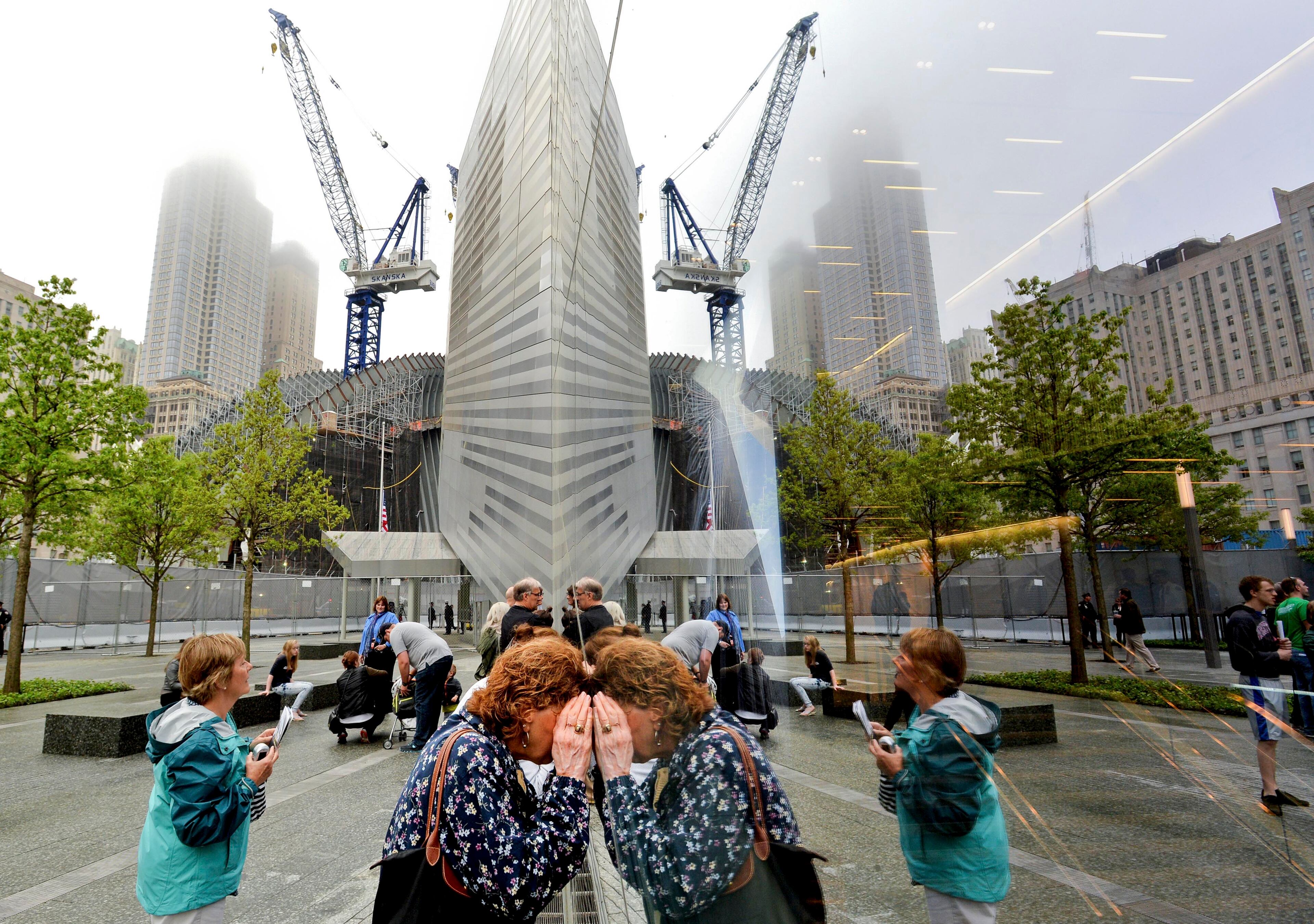 People try to look through the windows of the National September 11 Memorial Museum during the museum's dedication in New York, on Thursday, May 15, 2014. (AP Photo/Justin Lane, Pool)