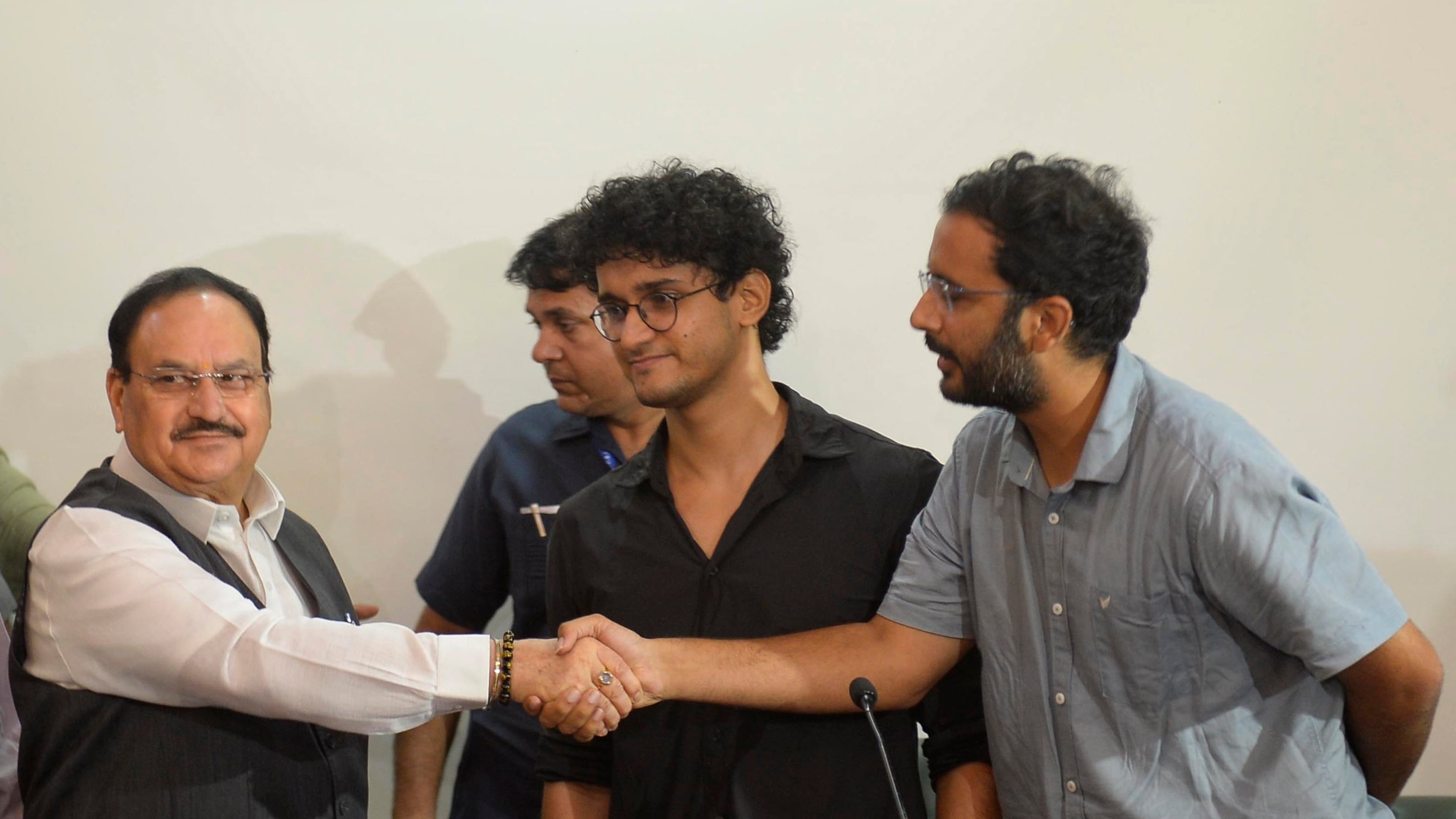FILE -Saurav Das, chief spokesperson of the Cockroach Janta Party, center, looks on as fellow spokesperson Ashutosh Ranka, right, shakes hands with India's Health Minister J.P. Nadda during a joint press conference in New Delhi, India, July 25, 2026, following the resignation of India's education minister. (AP Photo), File)