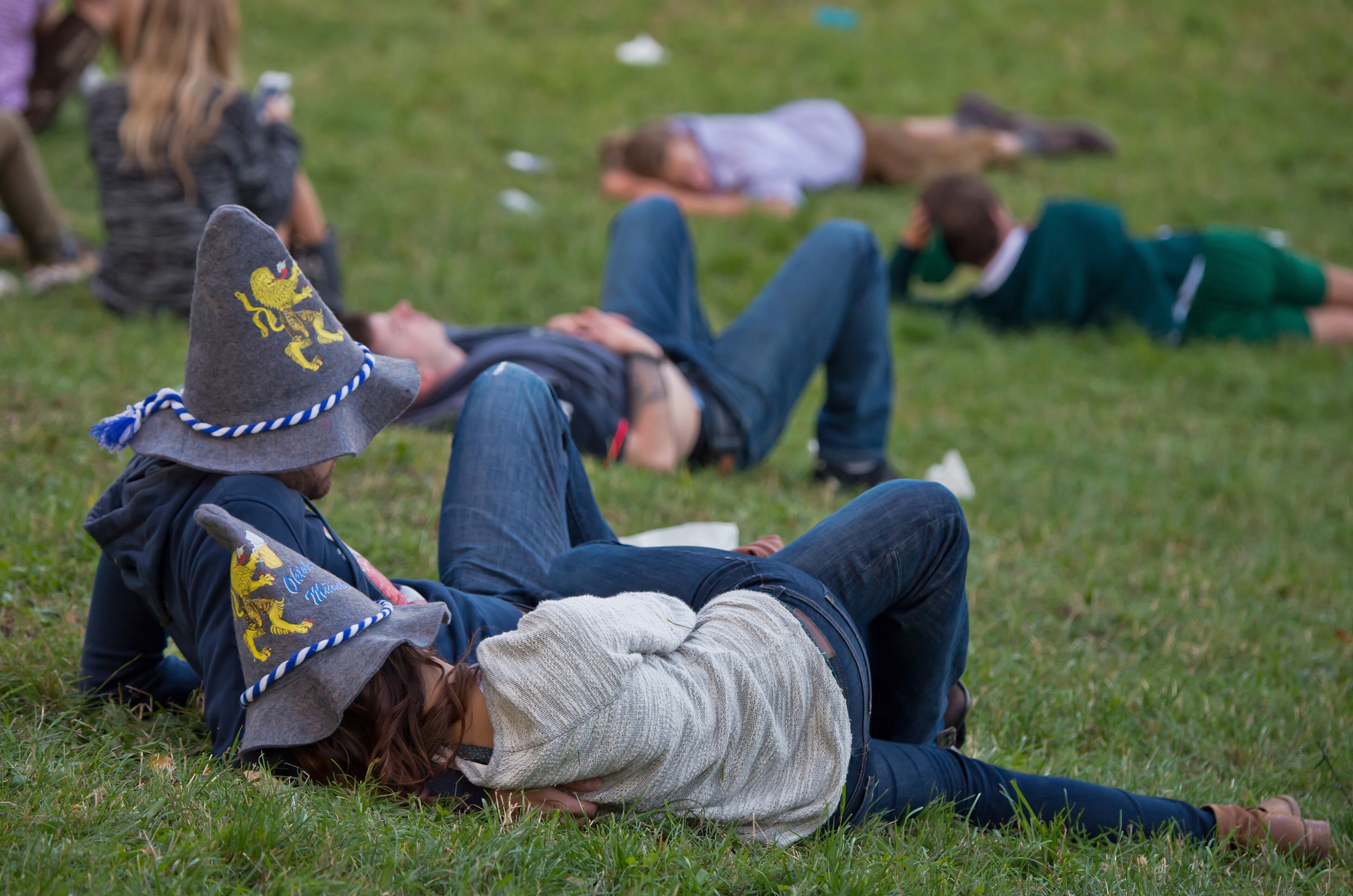 MUNICH, GERMANY - SEPTEMBER 21: Visitors relax on a field beside the Oktoberfest 2013 beer festival at Theresienwiese on September 21, 2013 in Munich, Germany. The Munich Oktoberfest, which this year will run from September 21 through October 6, is the world's largest beer fest and draws millions of visitors. (Photo by Joerg Koch/Getty Images)