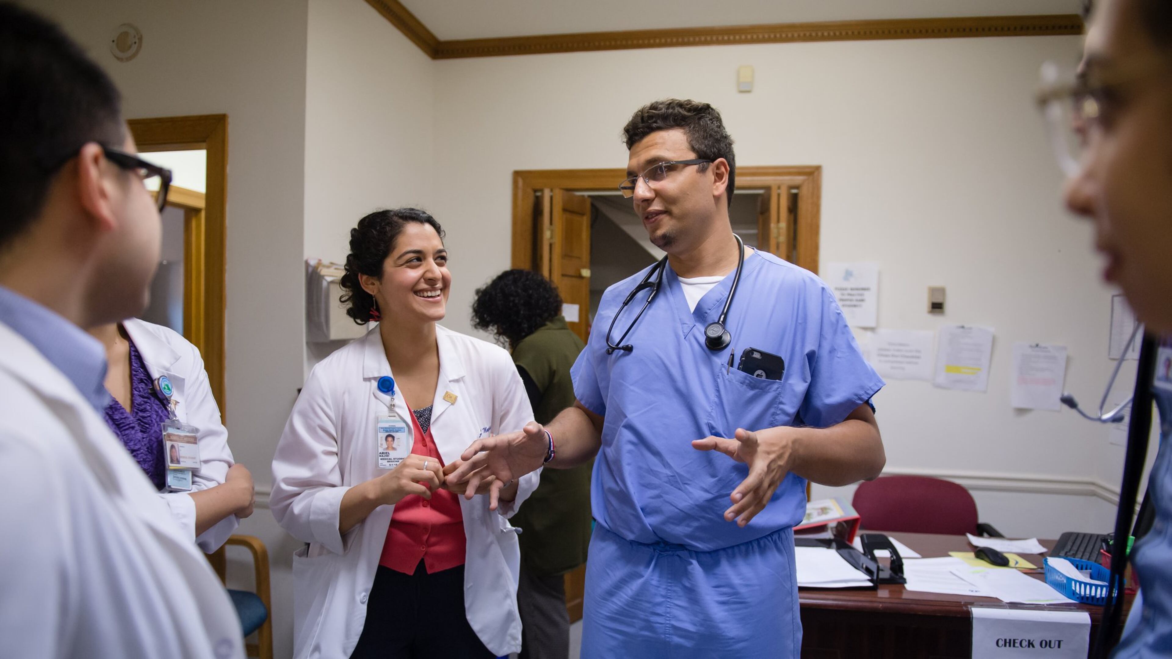 Dr. Heval Kelli (center in scrubs), a former Syrian refugee and current cardiology fellow at Emory University, speaks with medical students at the Clarkston Community Health Center in 2017. Kelli, who has previously volunteered at the clinic, is a Kurd who still has family in northeastern Syria where the withdrawal of U.S. troops has cleared the way for the Turkish military to attack U.S. allies who had helped fight ISIS. BITA HONARVAR/SPECIAL