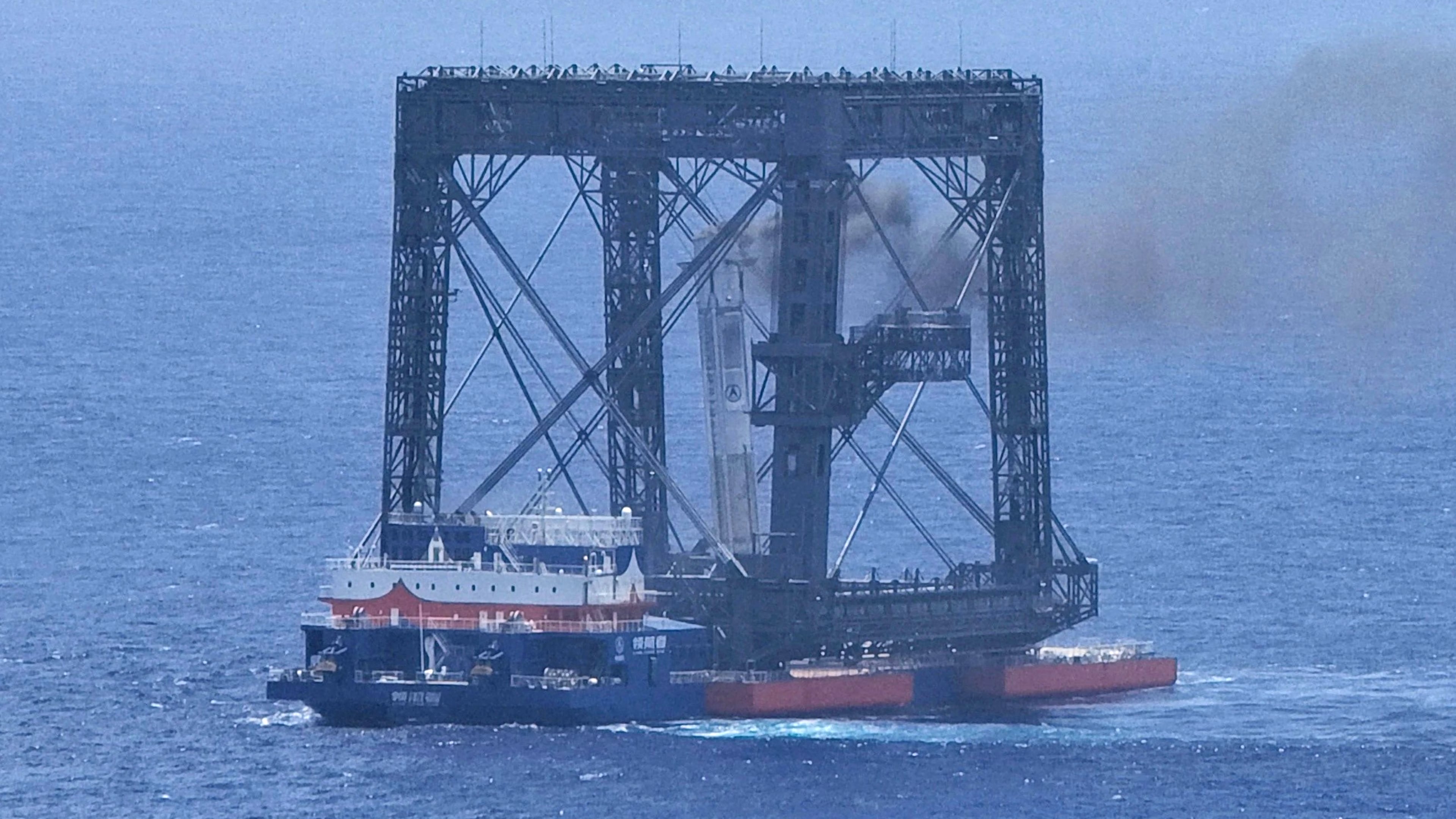 In this photo released by Xinhua News Agency, a drone photo shows the successful capture of the returned first stage of Long March-10B carrier rocket on a seaborne platform via a net-capture system near Wenchang in southern China's Hainan province on Friday, July 10, 2026. (Xing Guangli/Xinhua News Agency via AP)