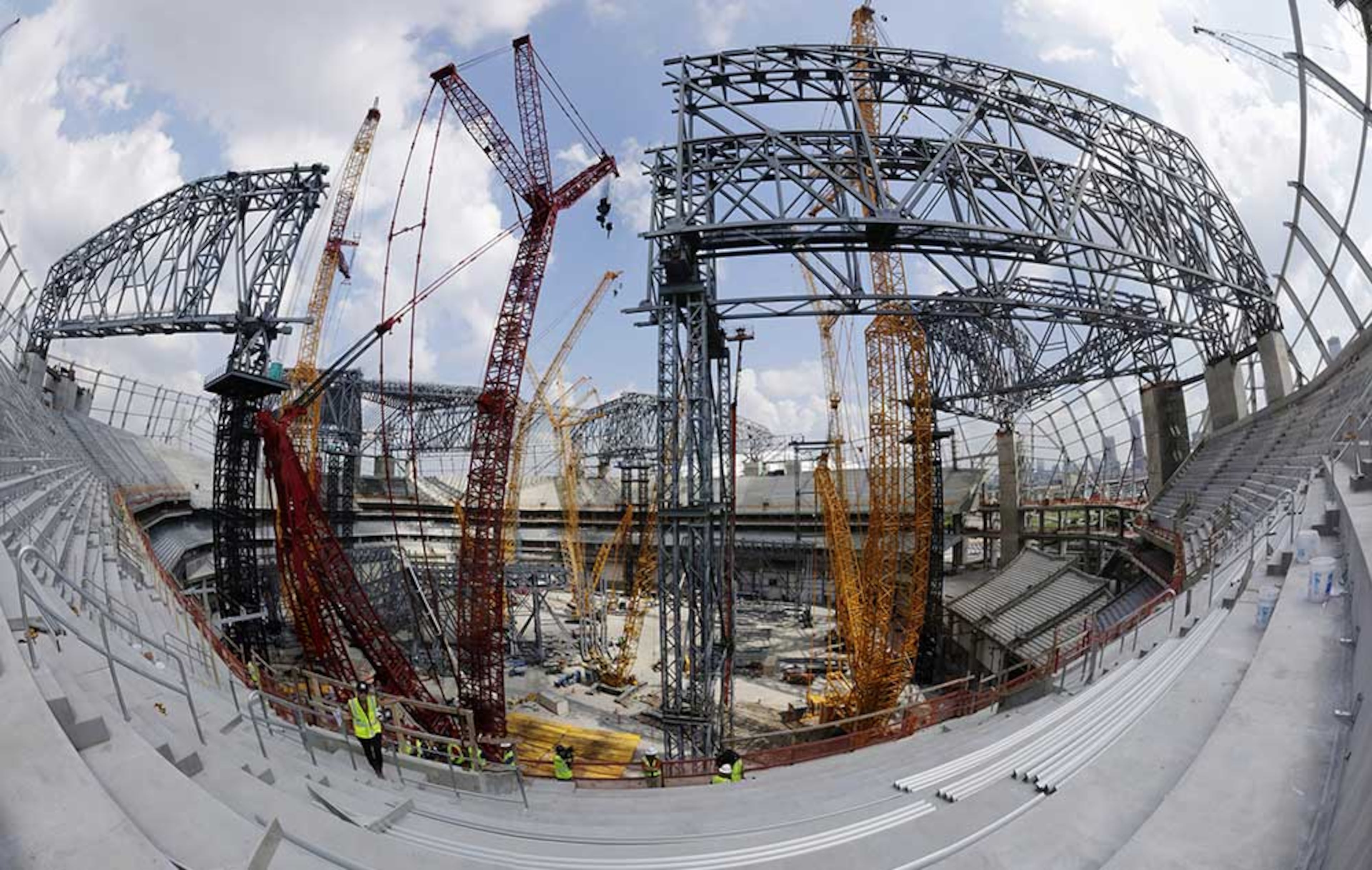 This fish eye view from the upper deck, stitched together from multiple photos, shows the field level is filled with steel work and cranes as tower construction and roof steel truss ground assembly continues inside the bowl.