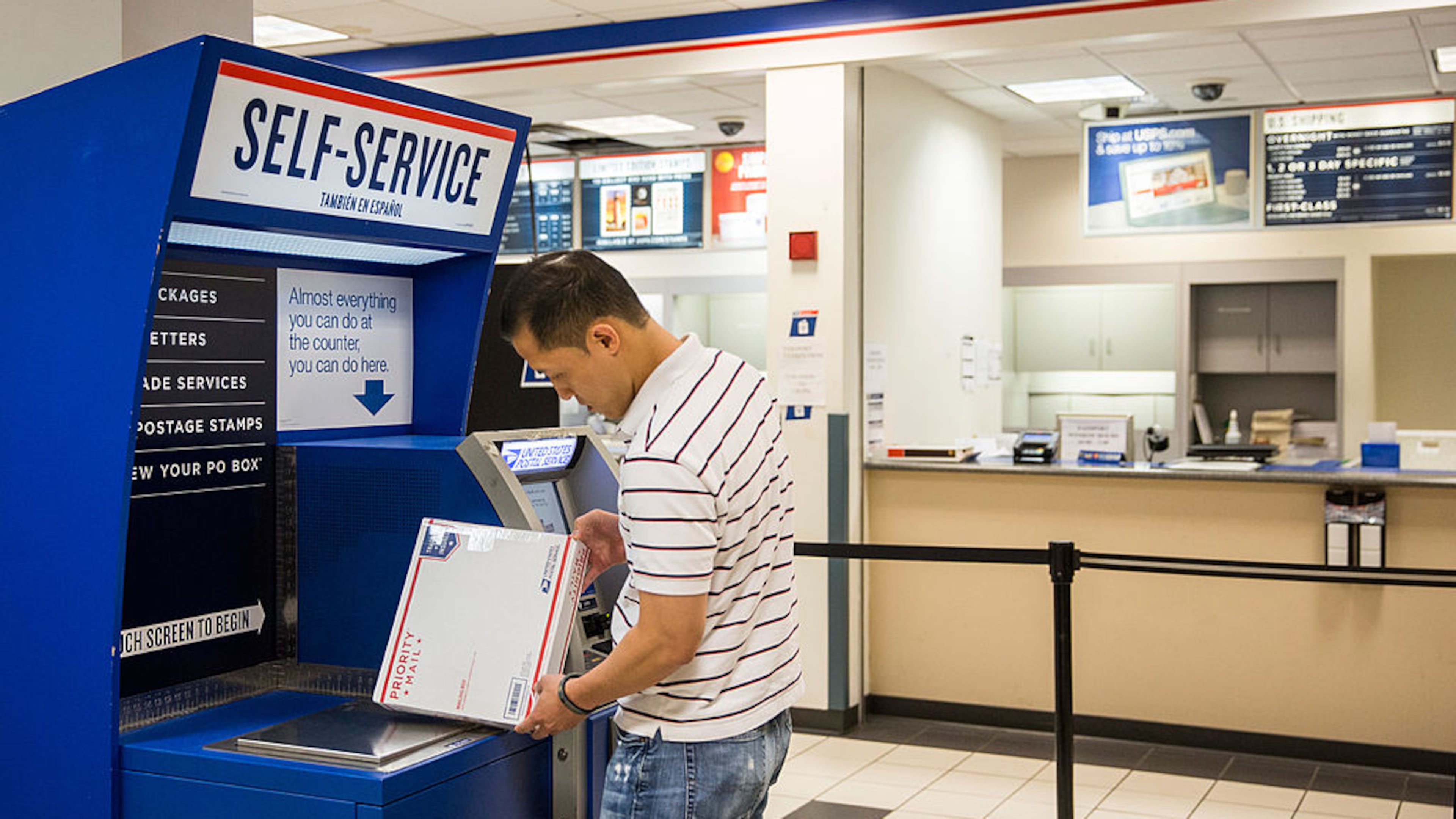 NEW YORK, NY - SEPTEMBER 25: A man uses a self service machine at a United States Post Office (USPS) on September 25, 2013 in New York City. The USPS announced today that they're considering raising the price of stamps by 3 cents. (Photo by Andrew Burton/Getty Images)
